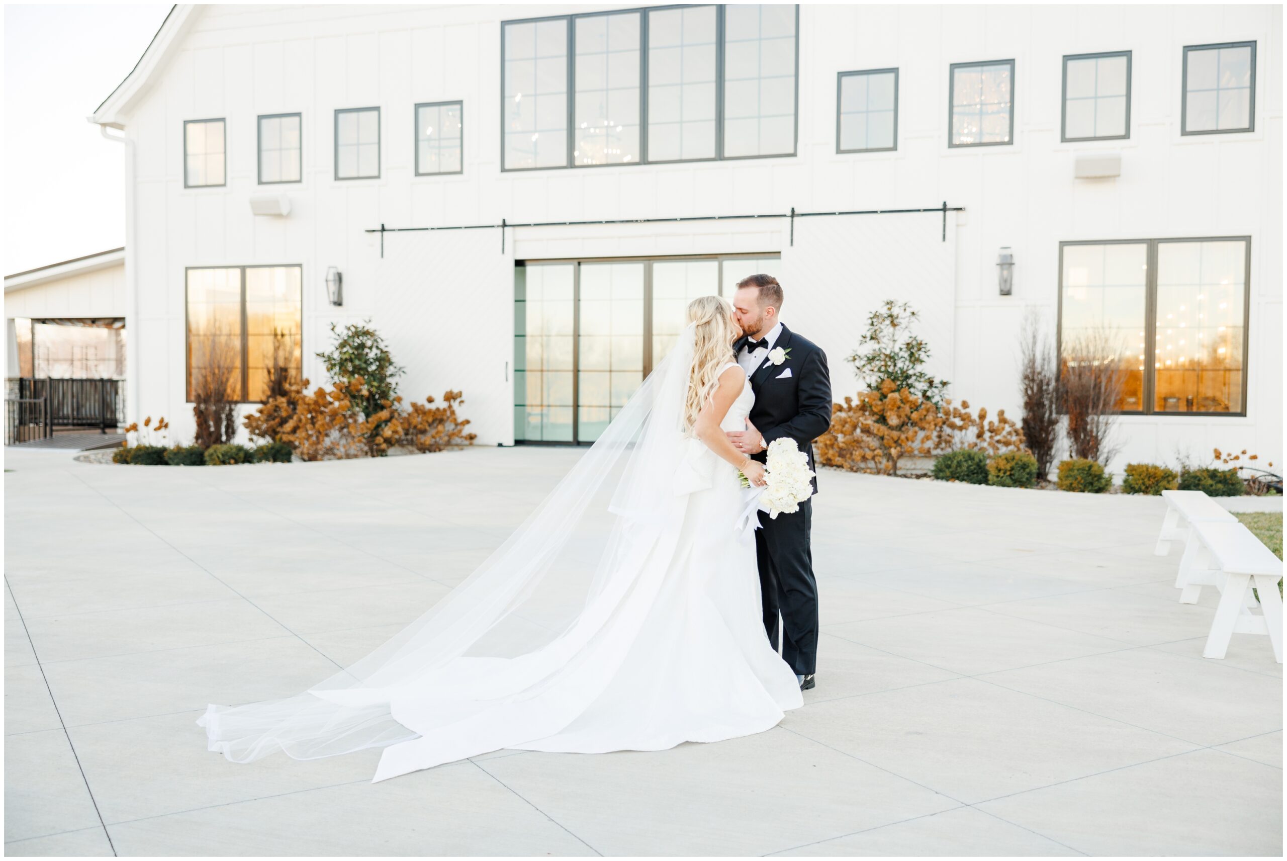 Portrait of bride and groom in front of White Iron Ridge wedding venue. Picture by Beneath the Spruce, a Kansas City Wedding Photographer.