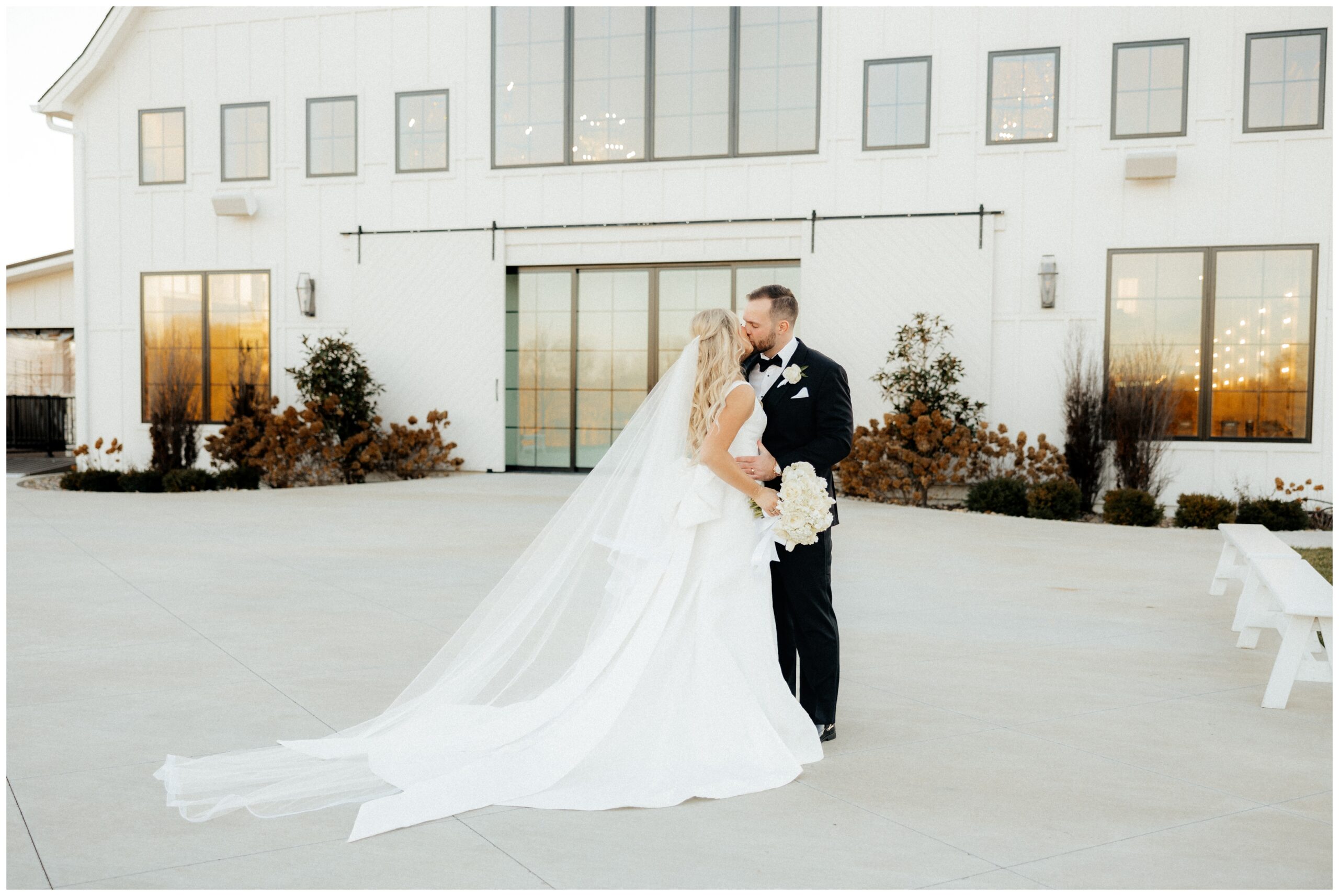 couple kissing in front of White Iron Ridge wedding venue.