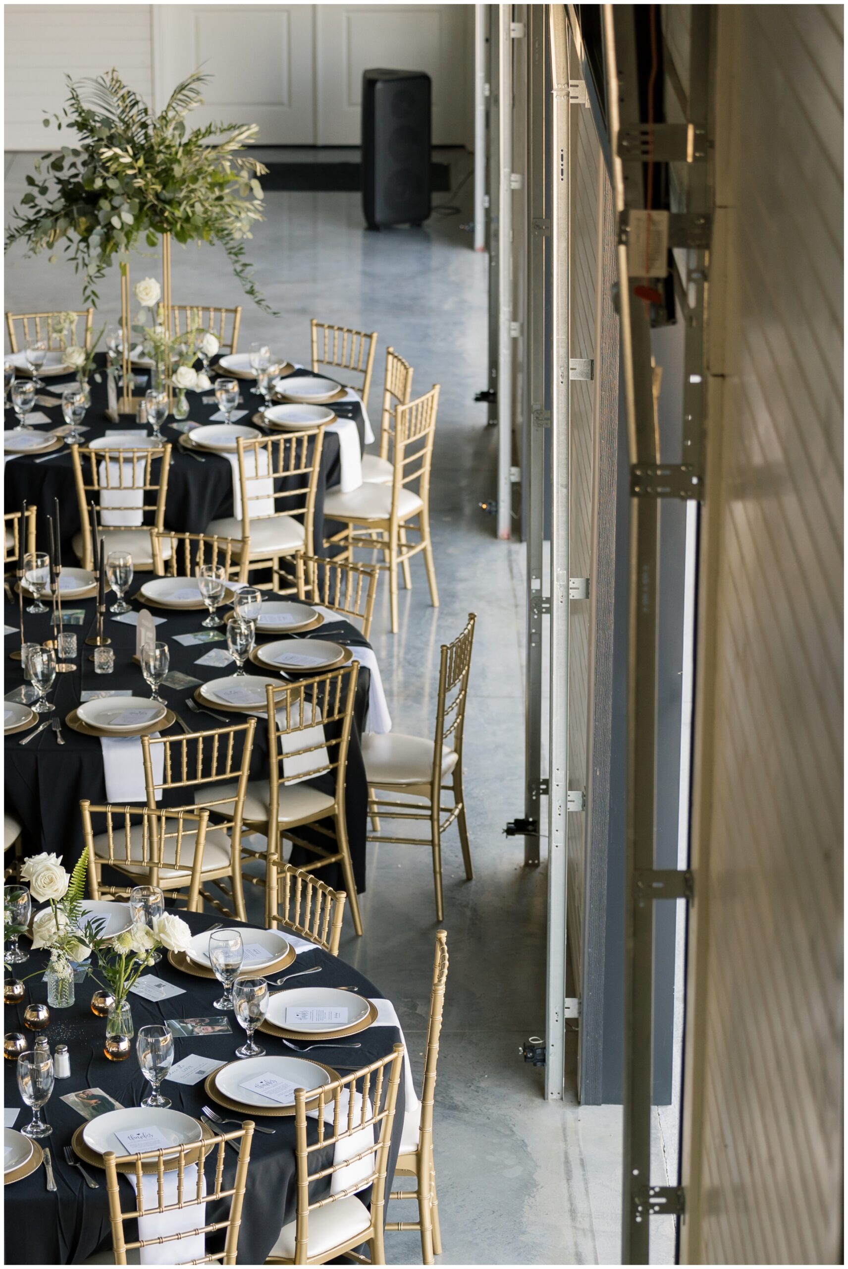 Elegant wedding reception setup inside a white barn venue.