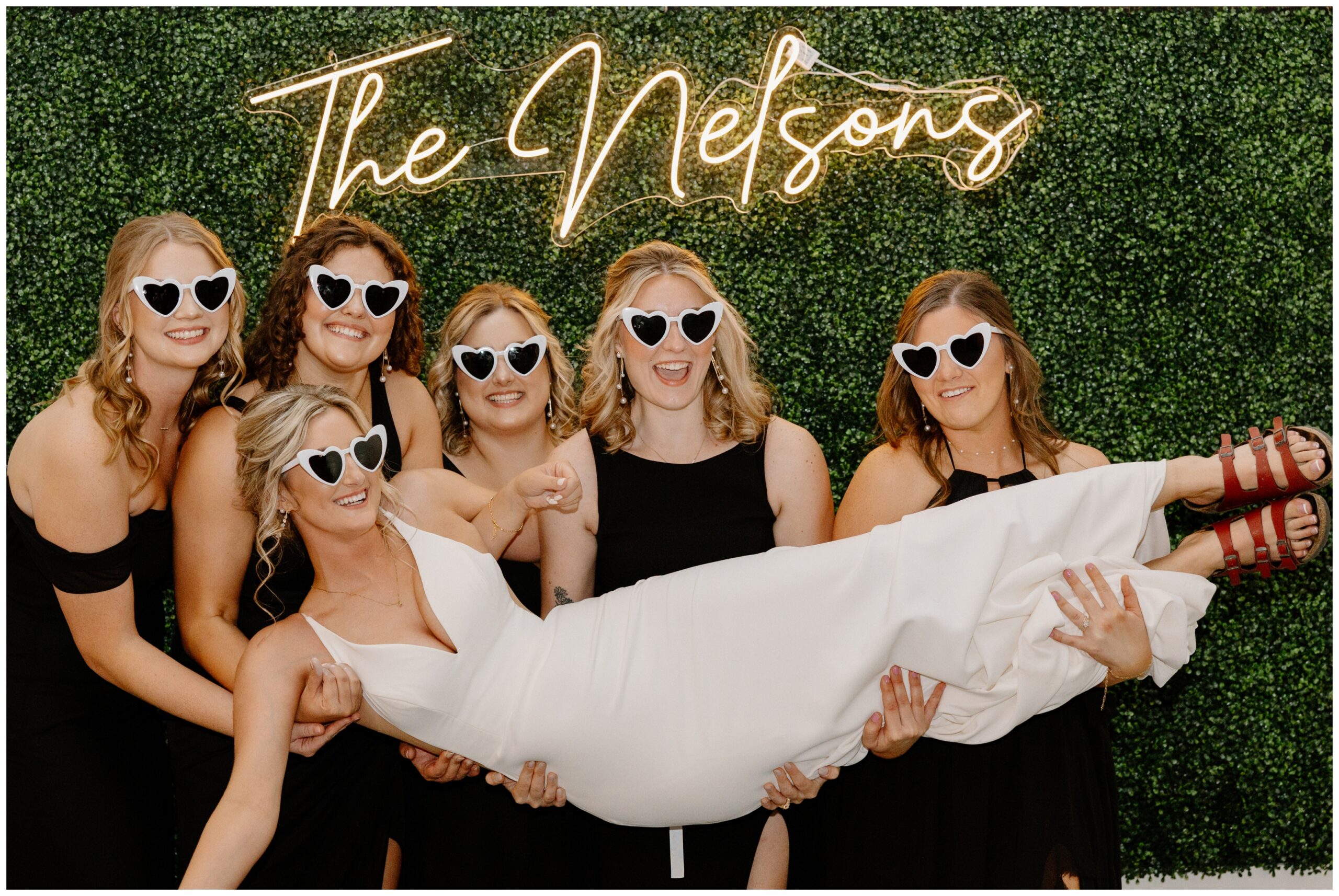 Neon sign backdrop at a classy barn wedding photobooth.