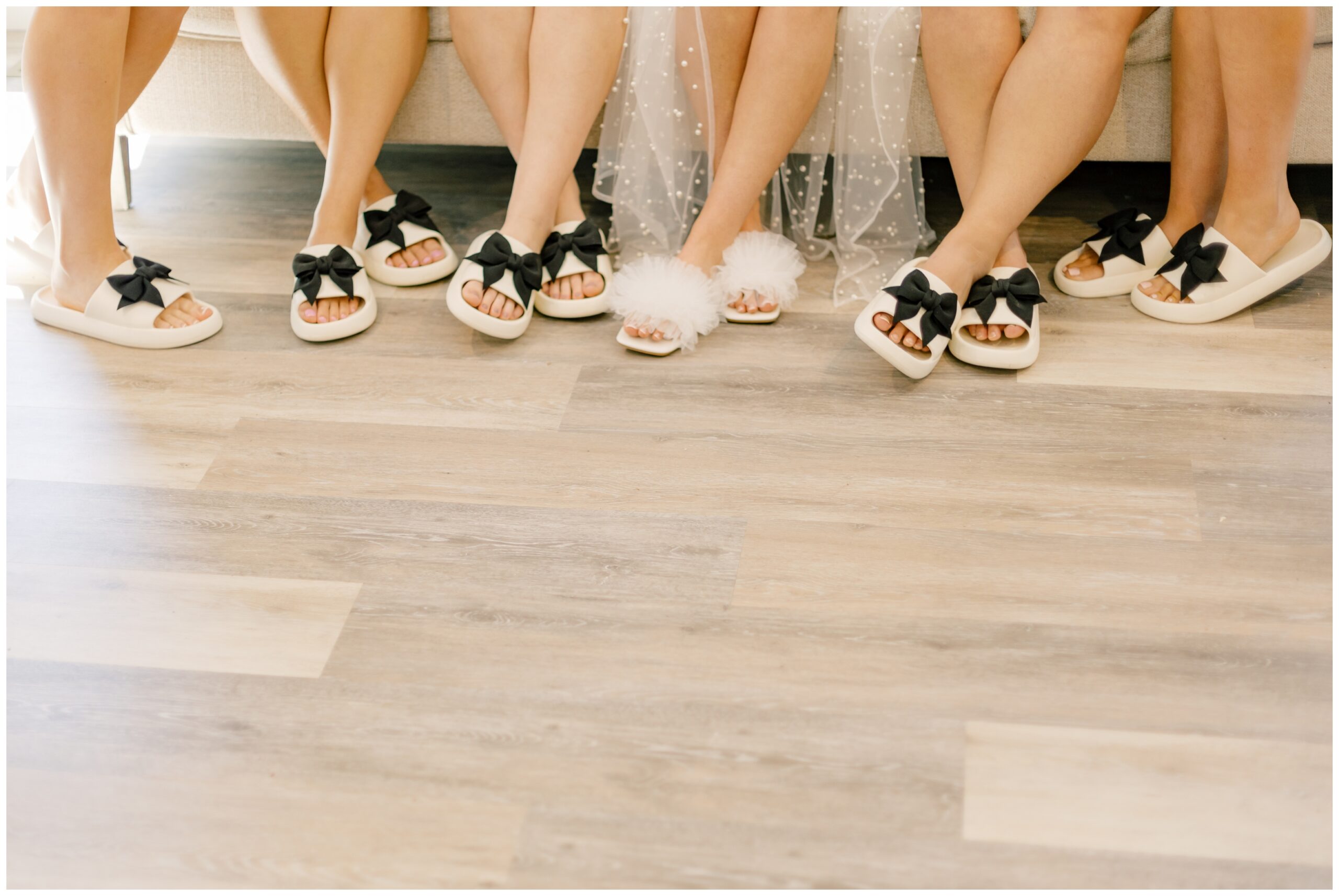 Bridesmaids in their matching white slides with black bows.