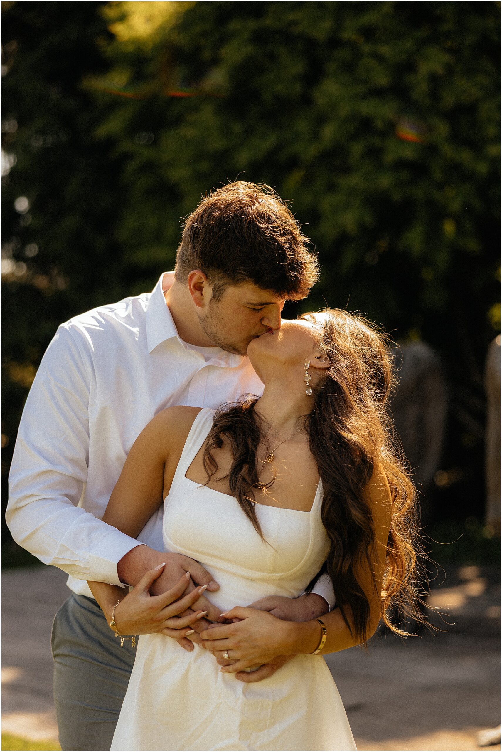 couple kissing in front of statues