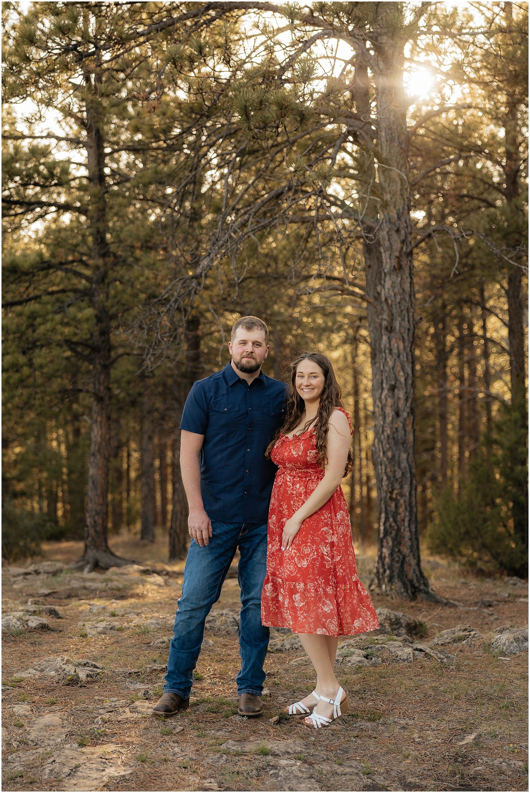 Couple smiling in front of pine trees