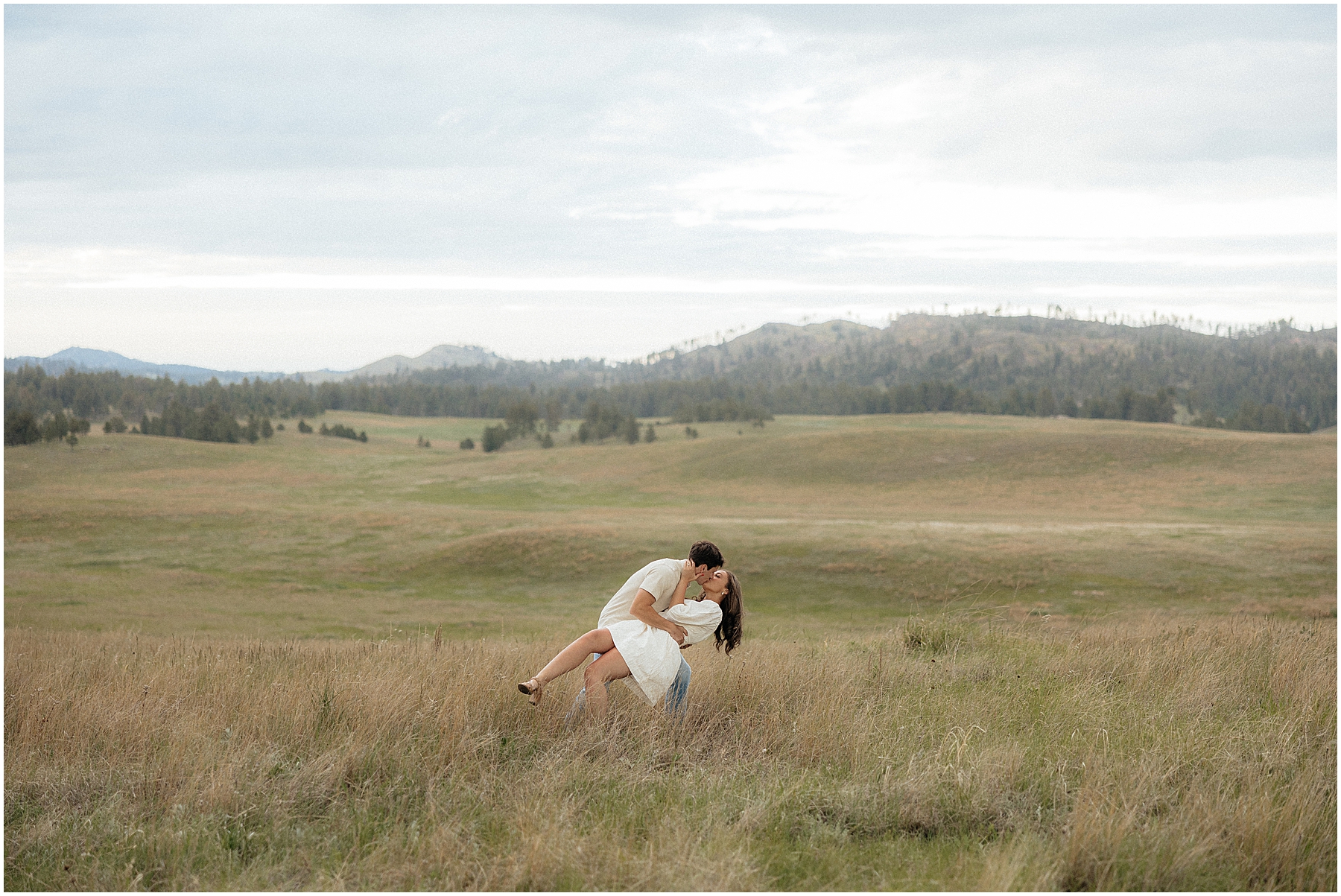 A couple dipping in front of a dramatic background.