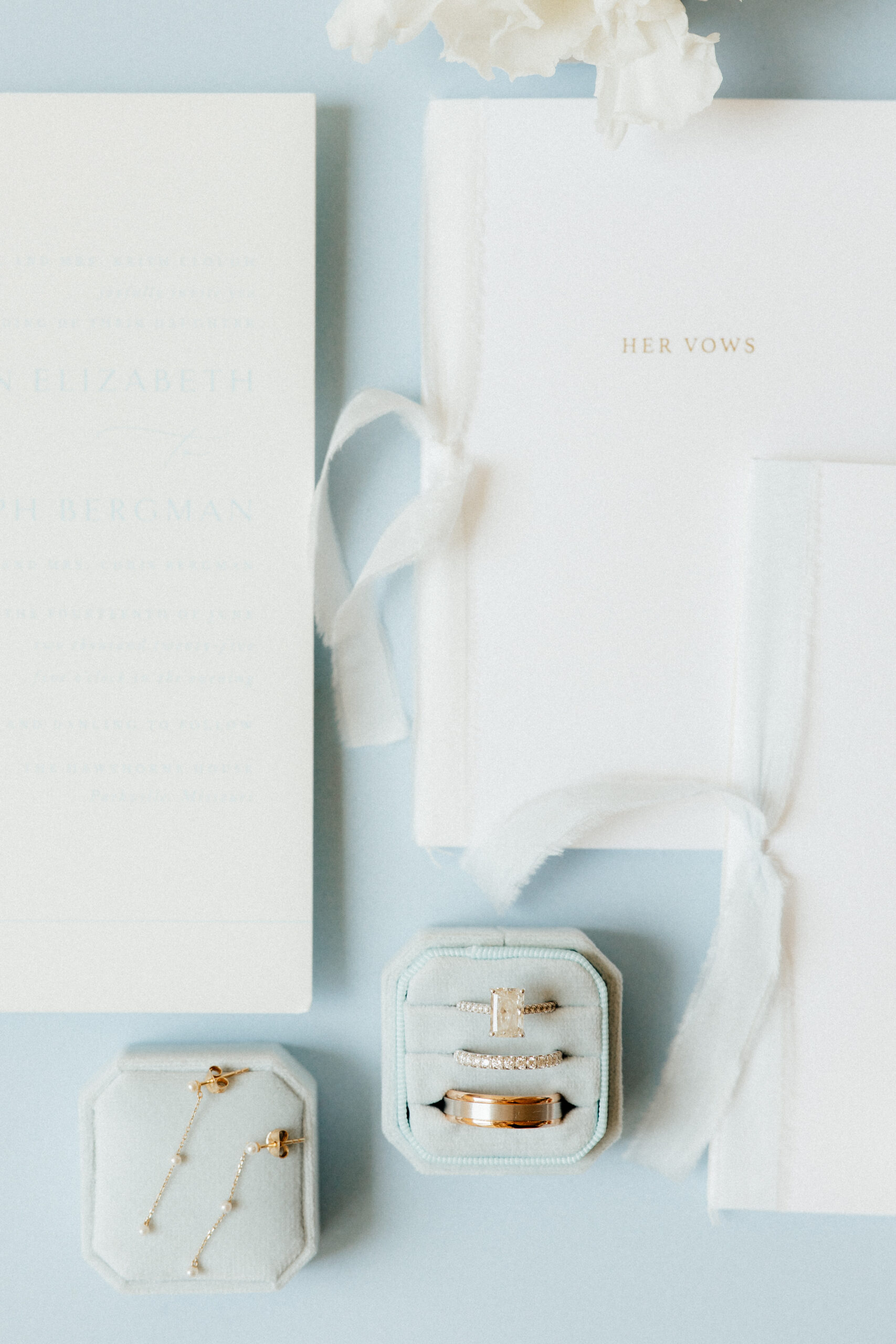 A beautiful engagement diamond ring and wedding bands in a soft blue ring box.