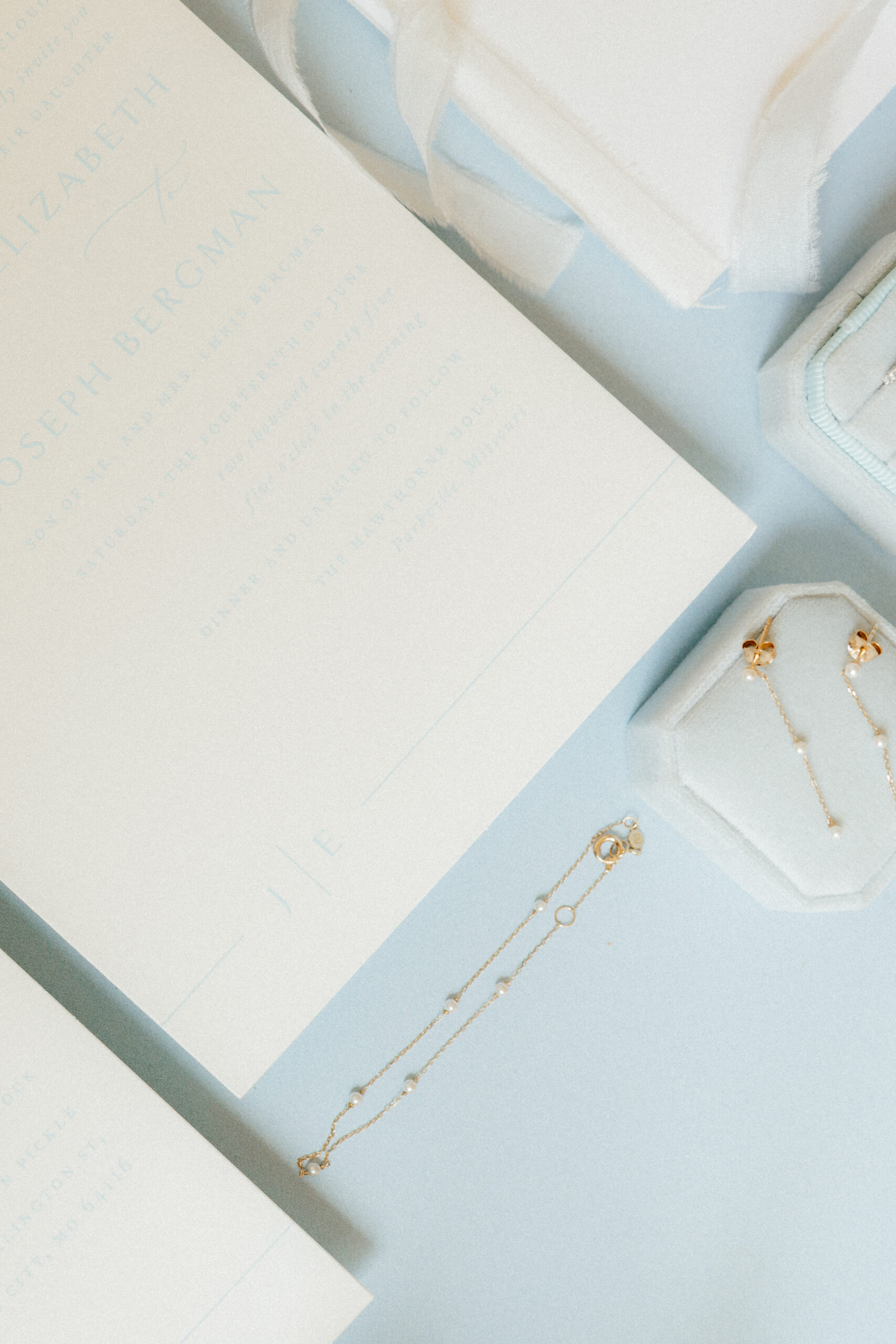 A beautiful engagement diamond ring and wedding bands in a soft blue ring box.