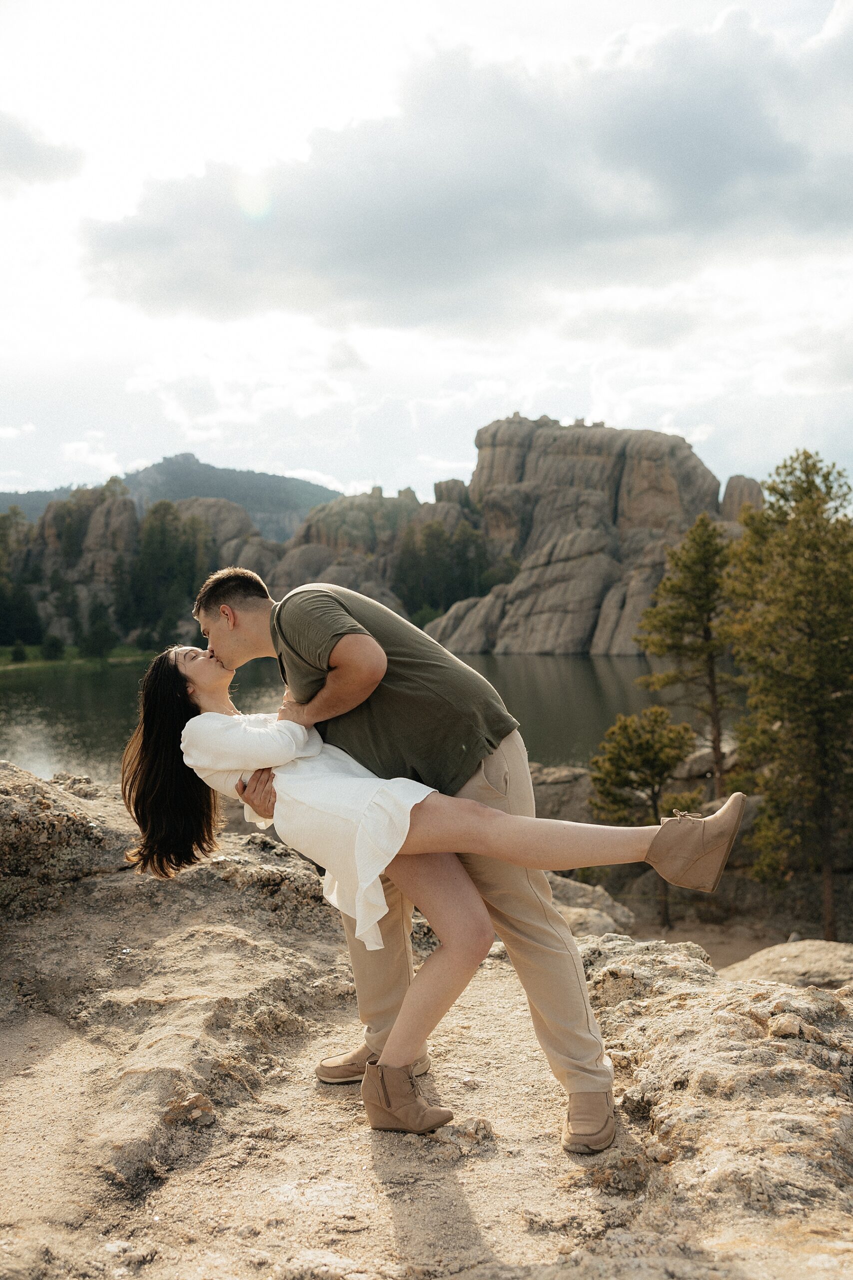 Harrison is dipping Emily with a beautiful lake behind them.