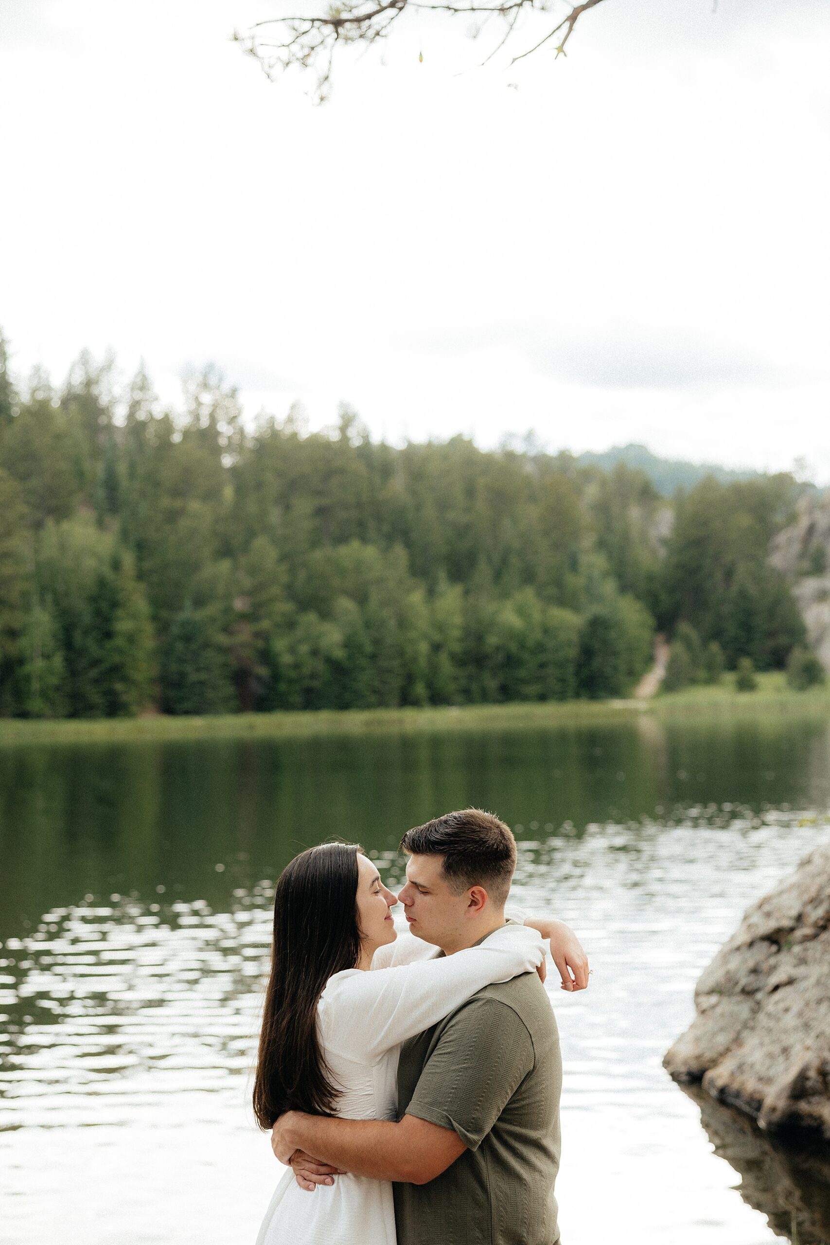 Emily wraps her arms around Harrison's neck as she pulls him in for a kiss.