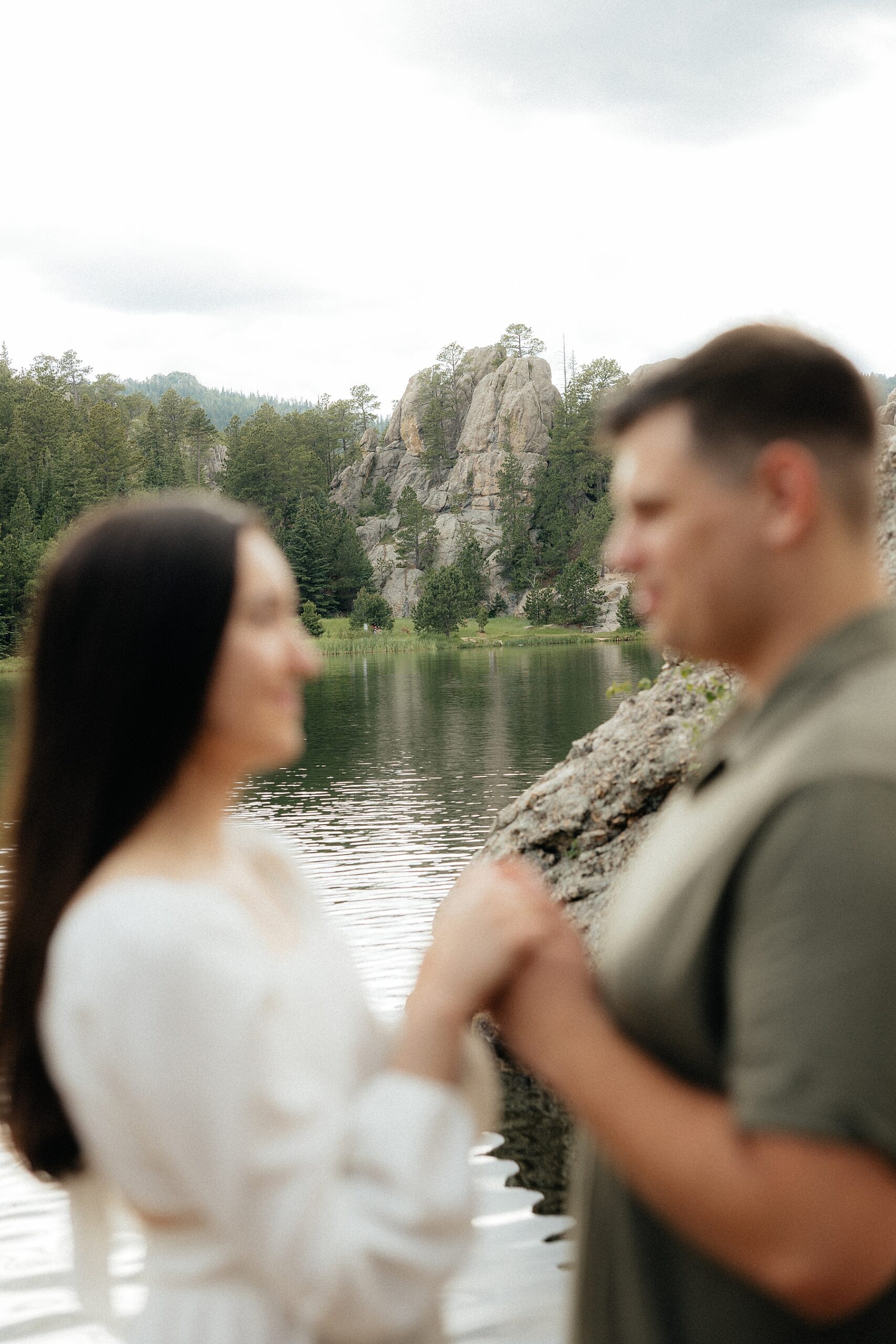 Emily + Harrison hand in hand. They're blurry, but the rock formation behind them is in focus.