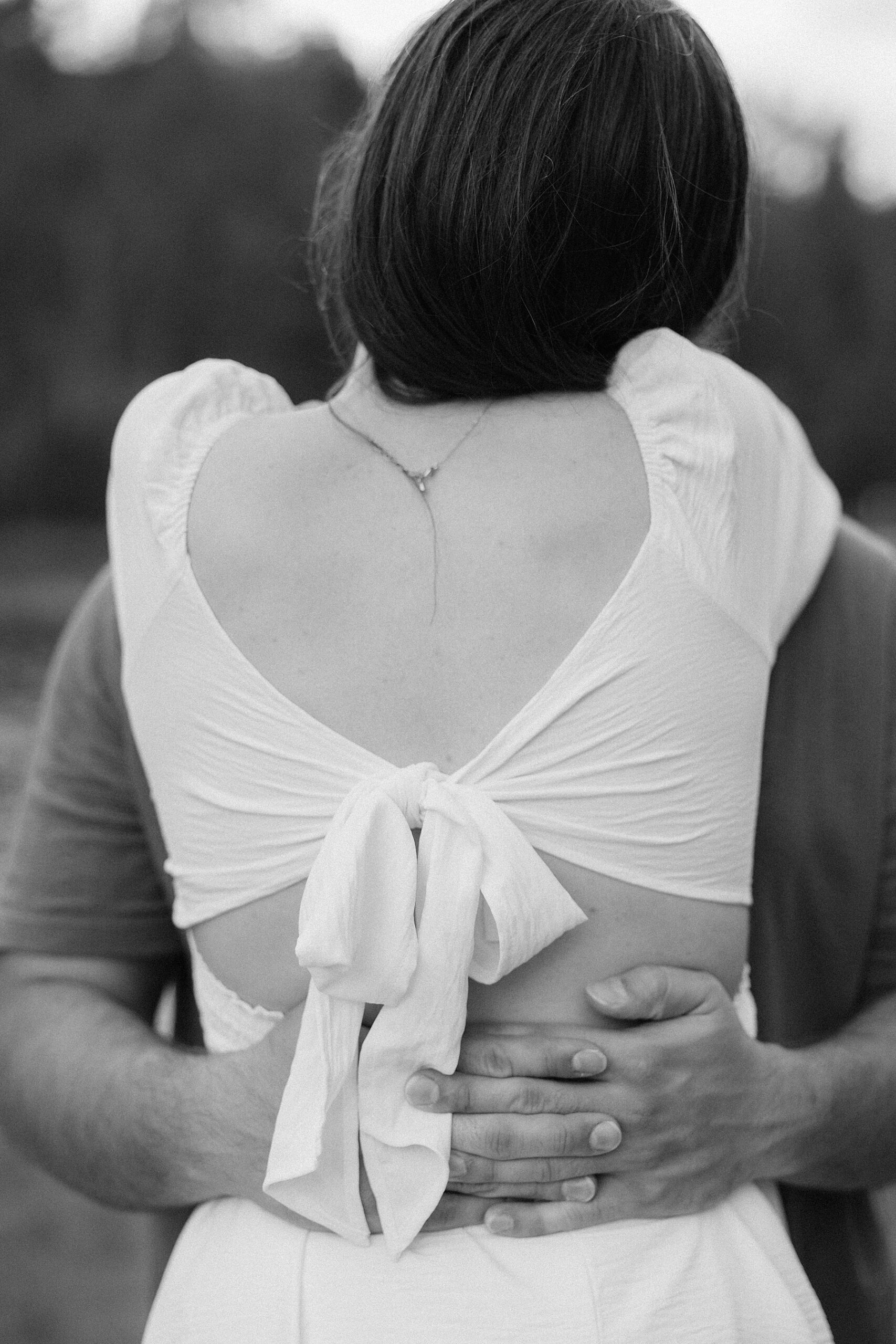 Harrison wraps his arms around Emily and holds her close.