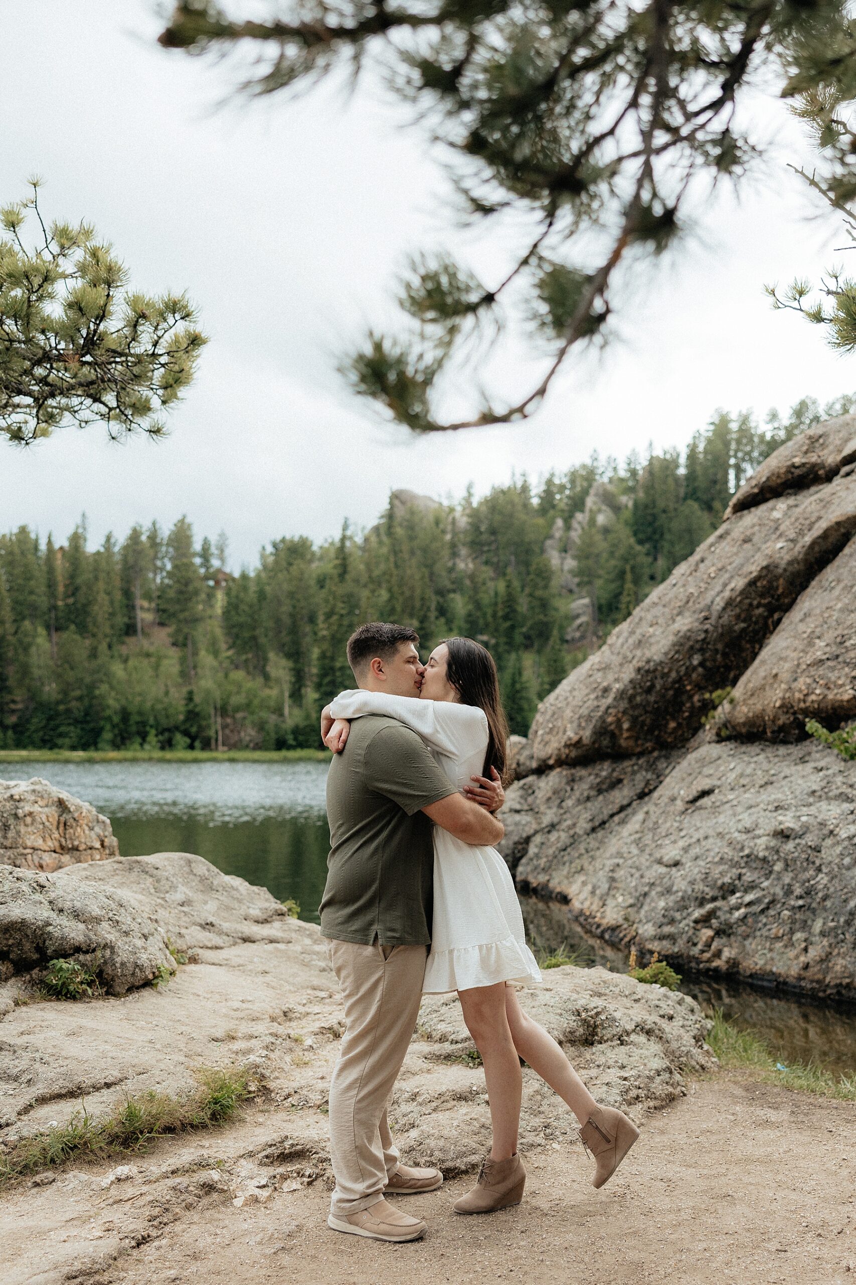 Emily and Harrison wrap each other in a hug and kiss.