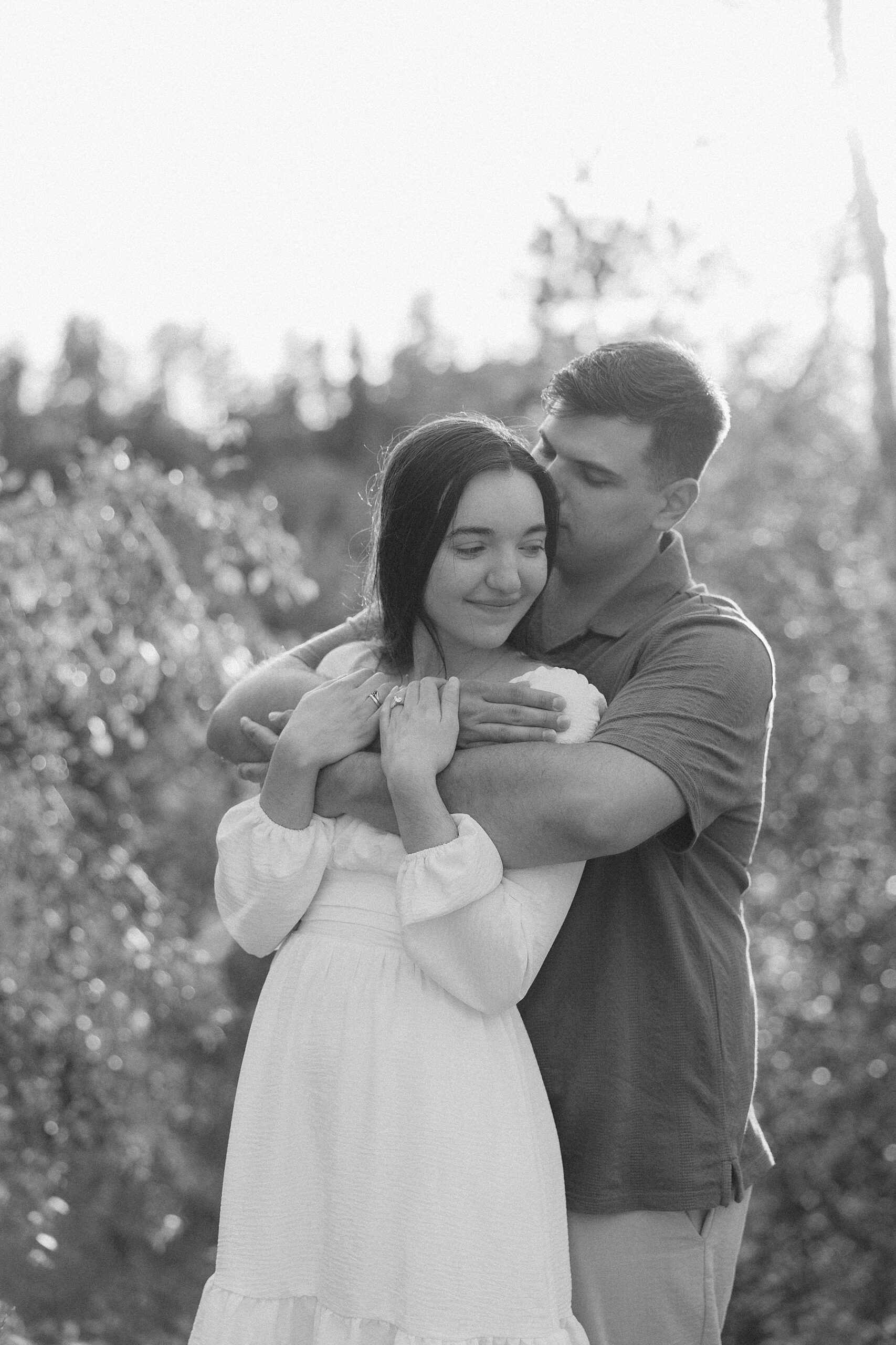 Harrison wrapping his arms around Emily and pulls her in to a tight embrace.