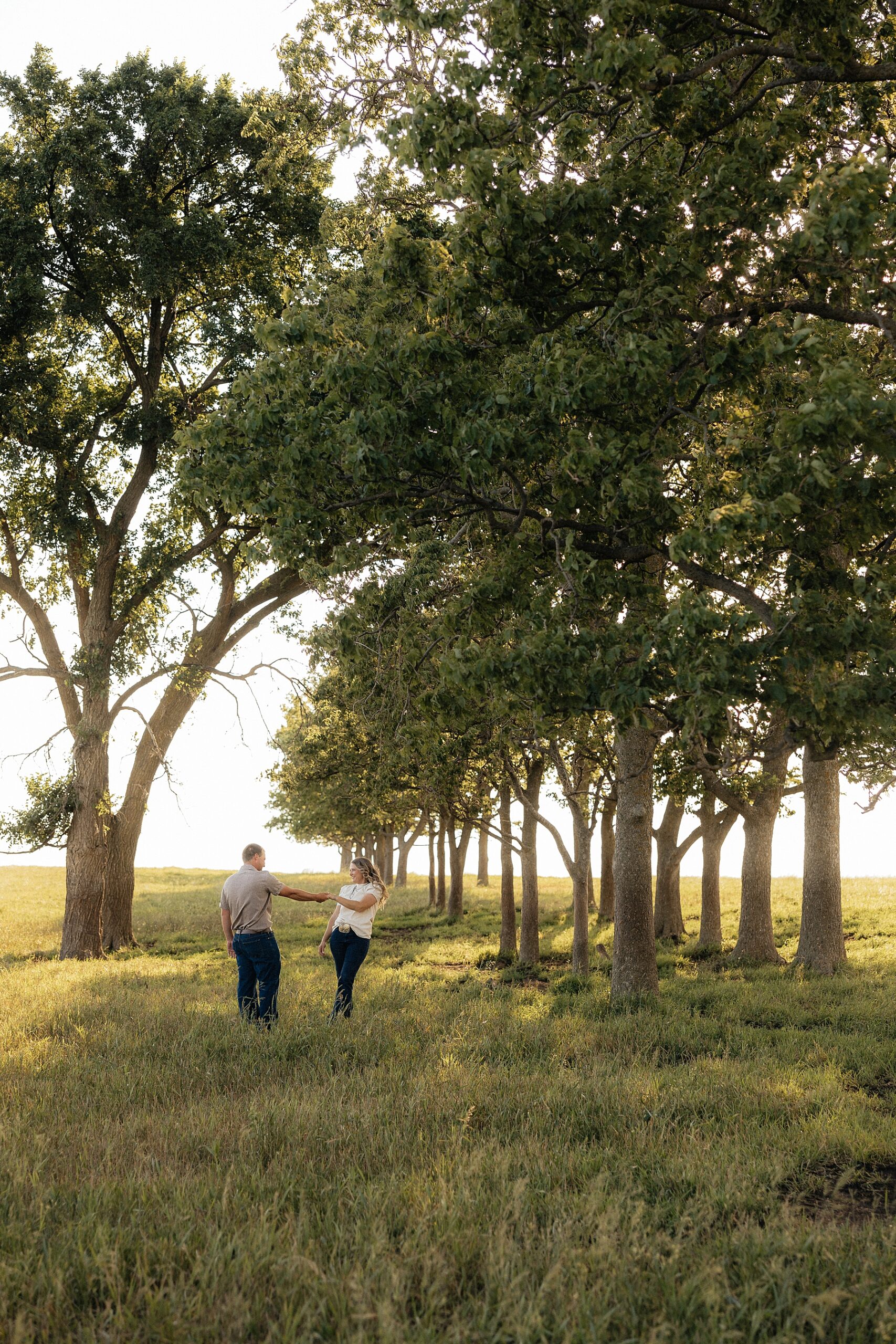 A couple having a playful moment in a field.