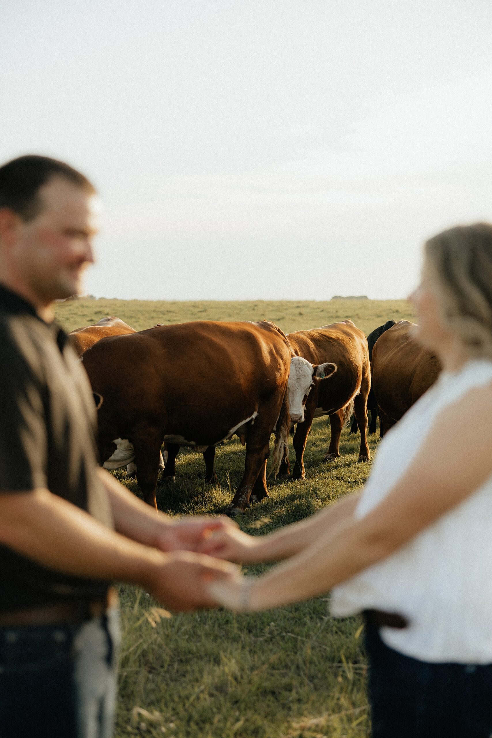 A couple with cattle behind them.