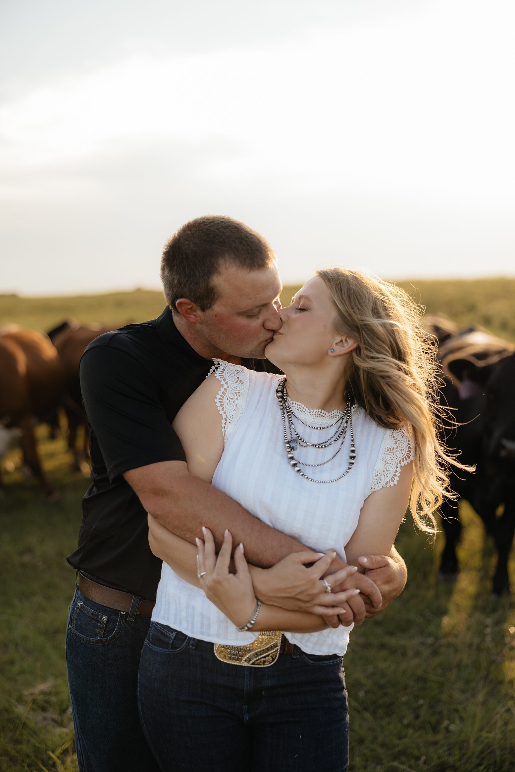 A couple kissing in a field.