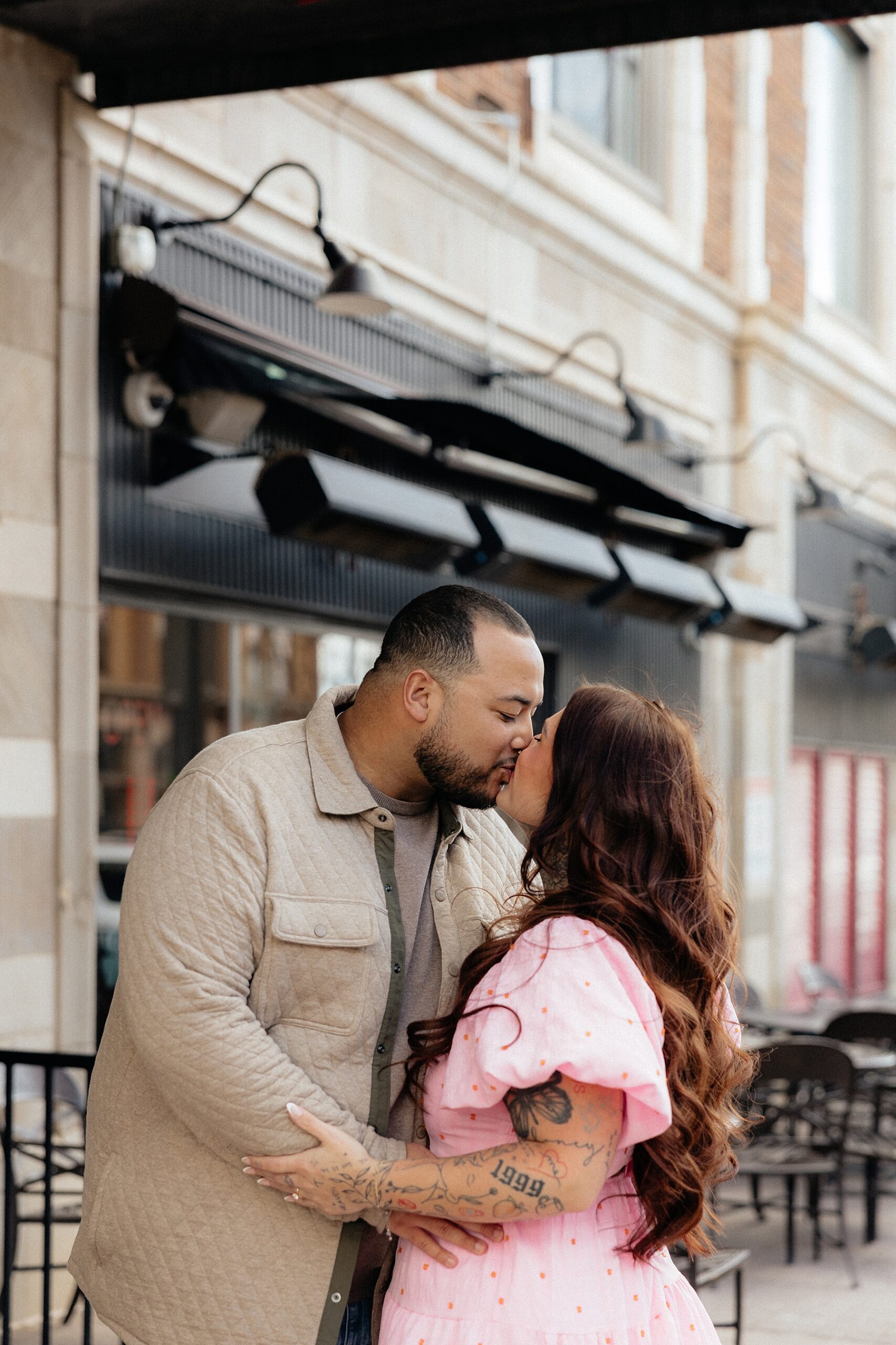 A couple wearing outfits that complement each other at their downtown engagement session.