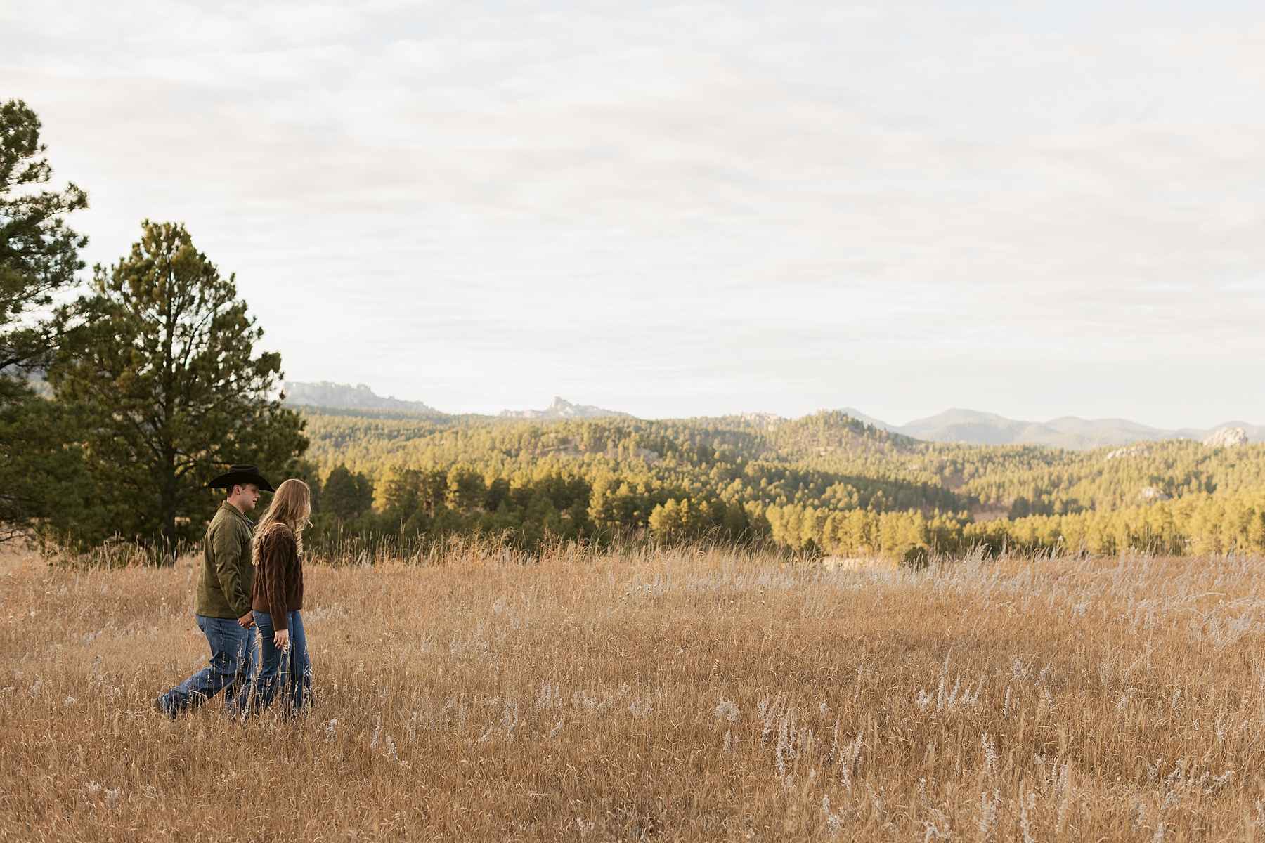 Jordan and Emma walking across a field in the Black Hills.