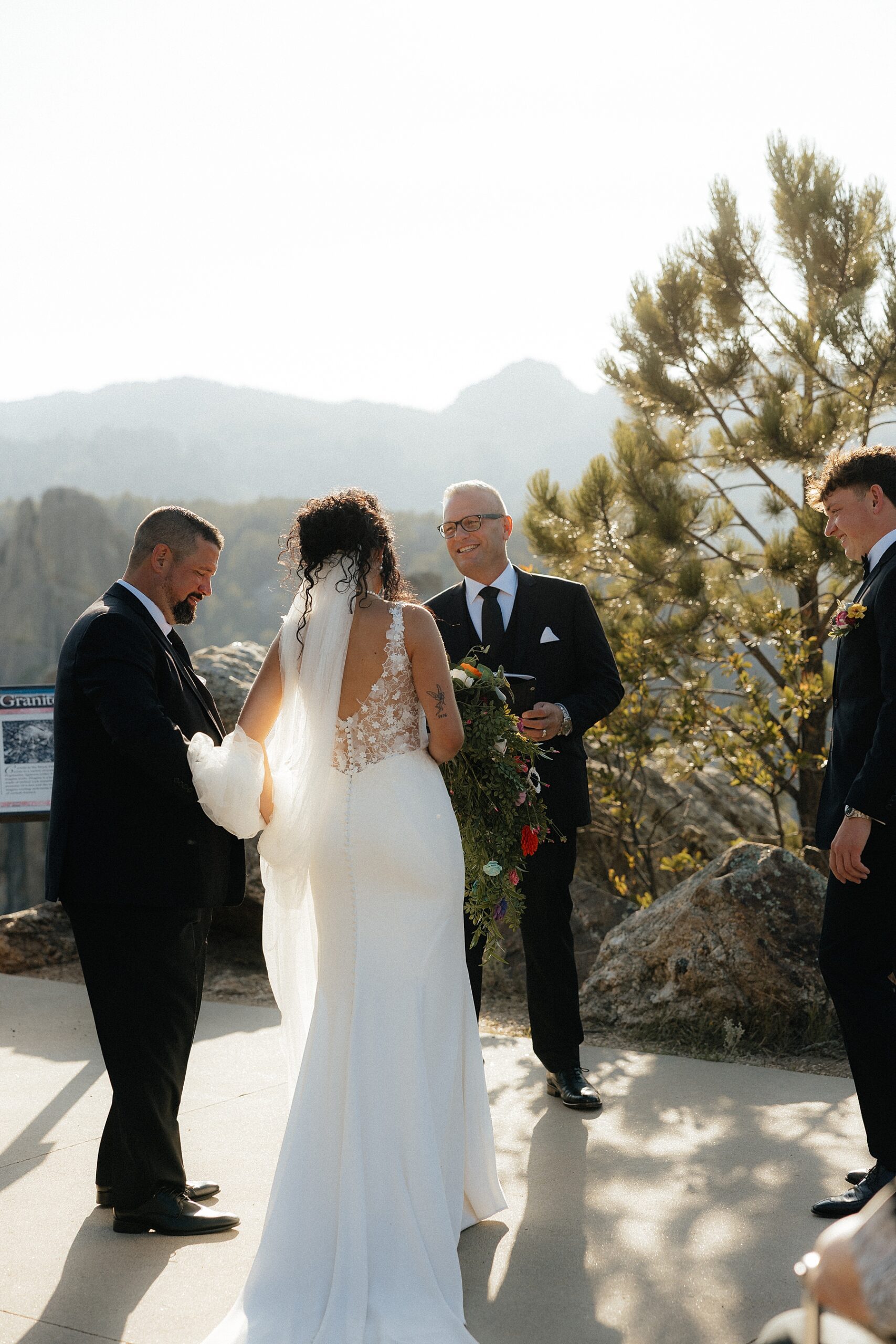 The bride walking to her groom with the views of the Black Hills behind her.