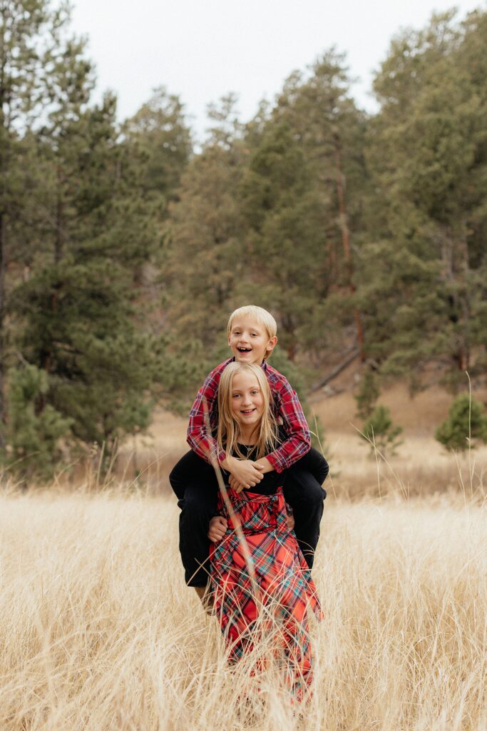 A sister giving her brother a piggy back ride.