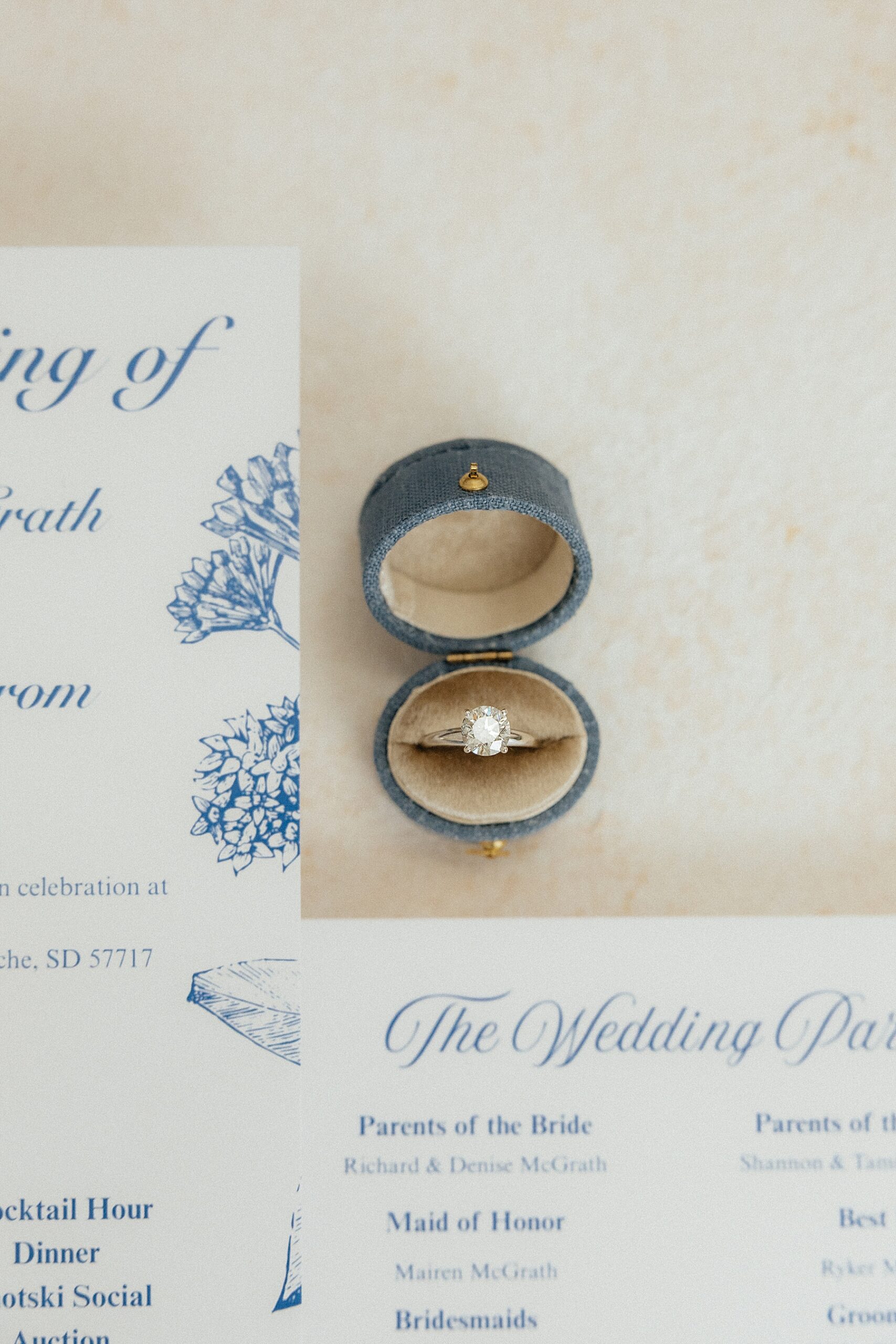 A diamond engagement ring in a vintage-style linen ring box.