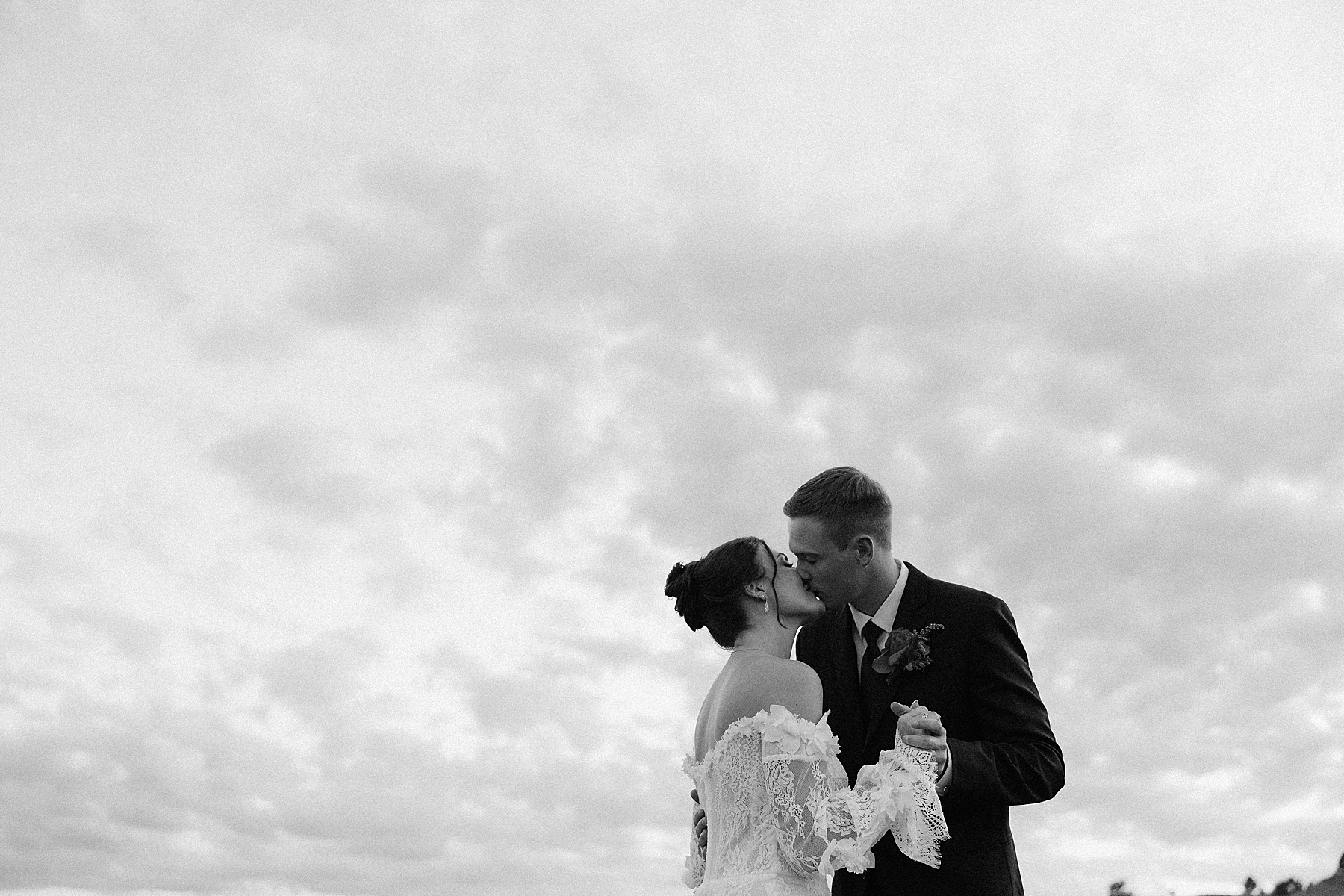 The bride and groom kissing at golden hour.