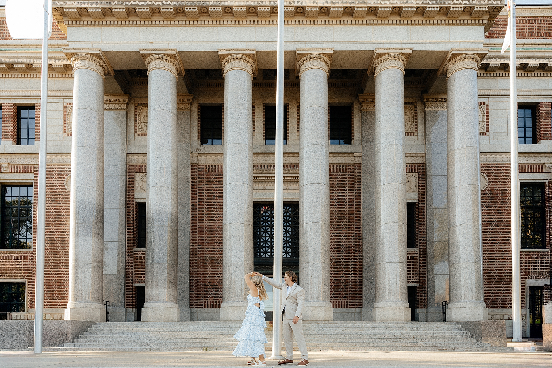 Michael spins Karissa in front of the St. Cloud courthouse at their creative engagement session.