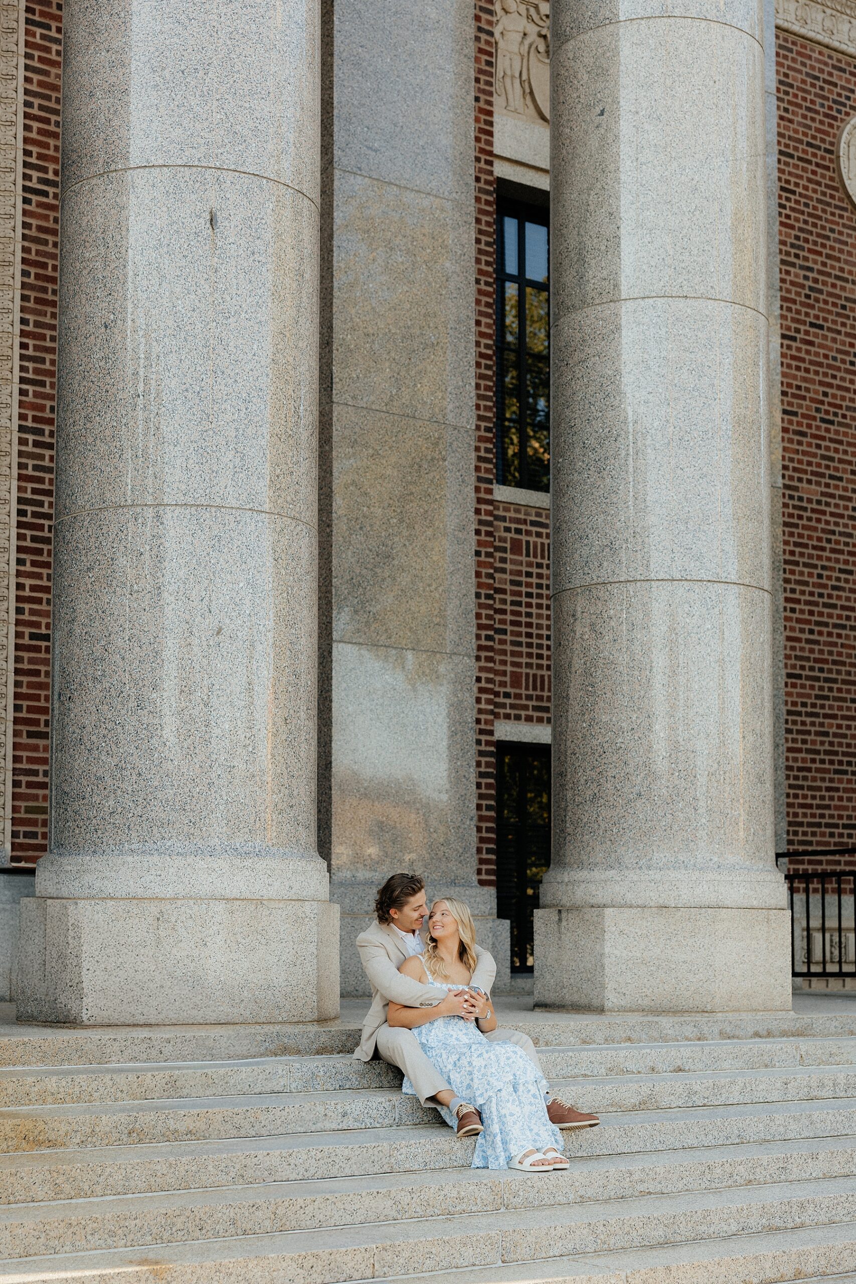 A couple sitting on the stairs at a courthouse.