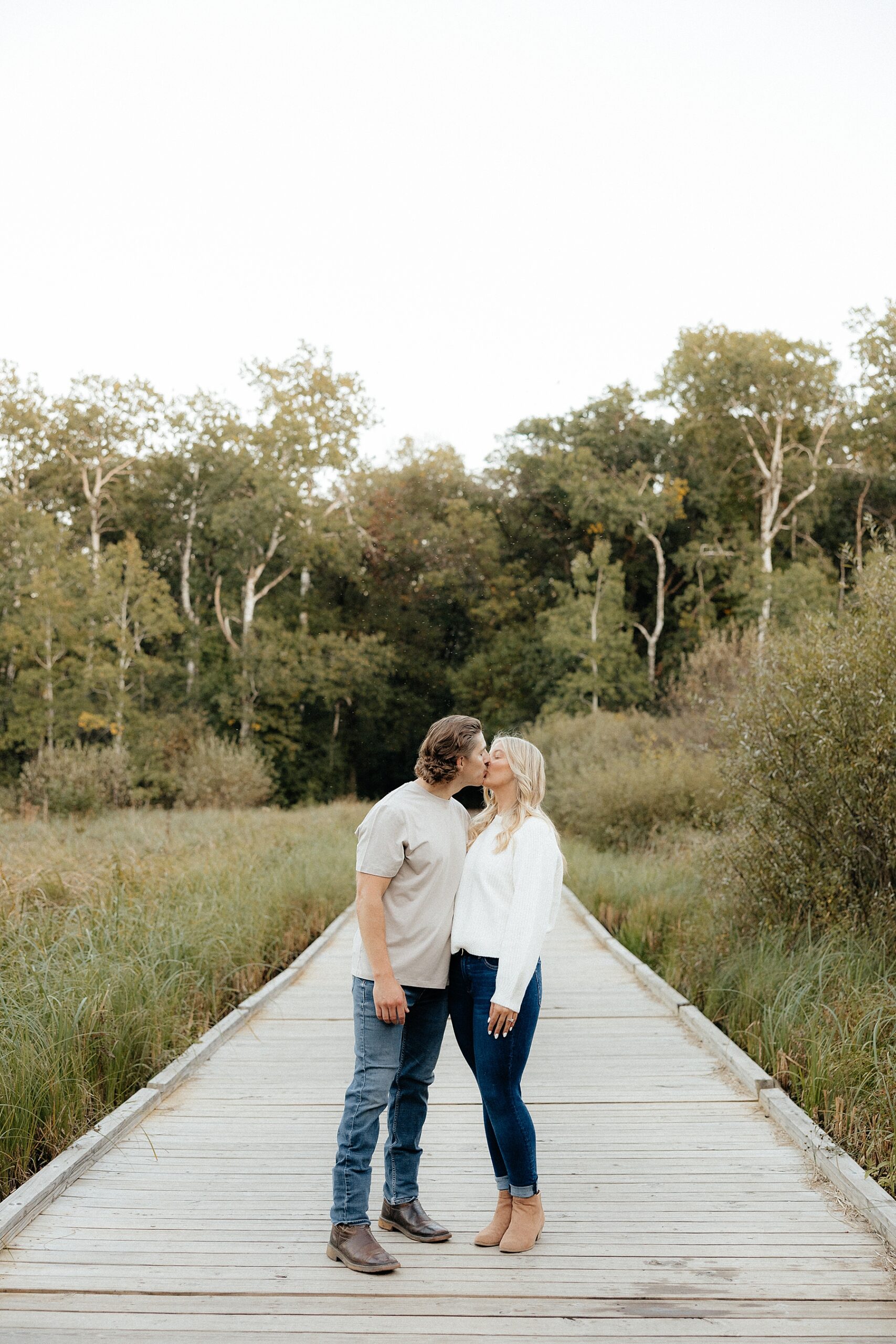 Karissa and Michael kiss on the wood bridge.