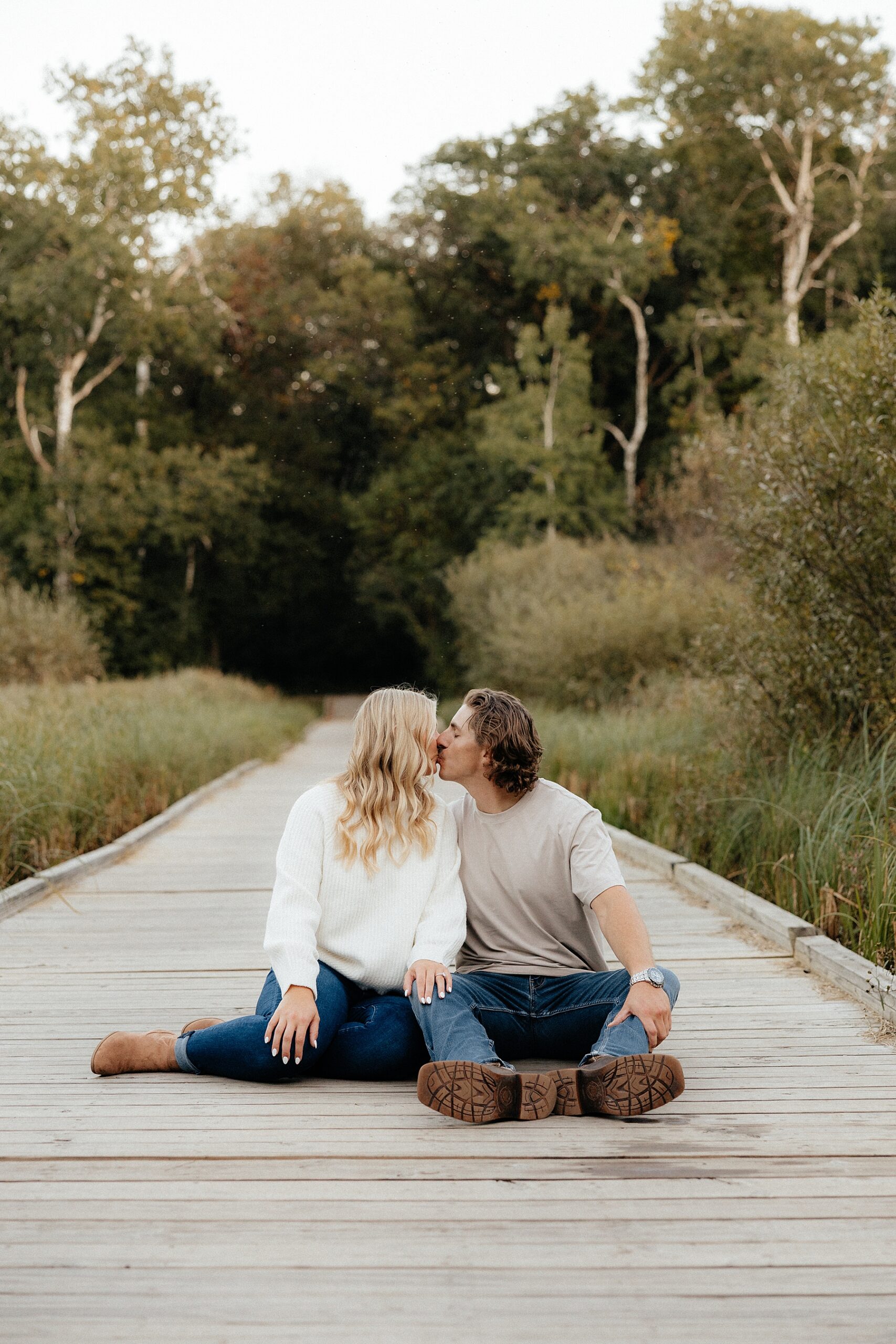 Karissa and Michael kiss on a wooden boardwalk.
