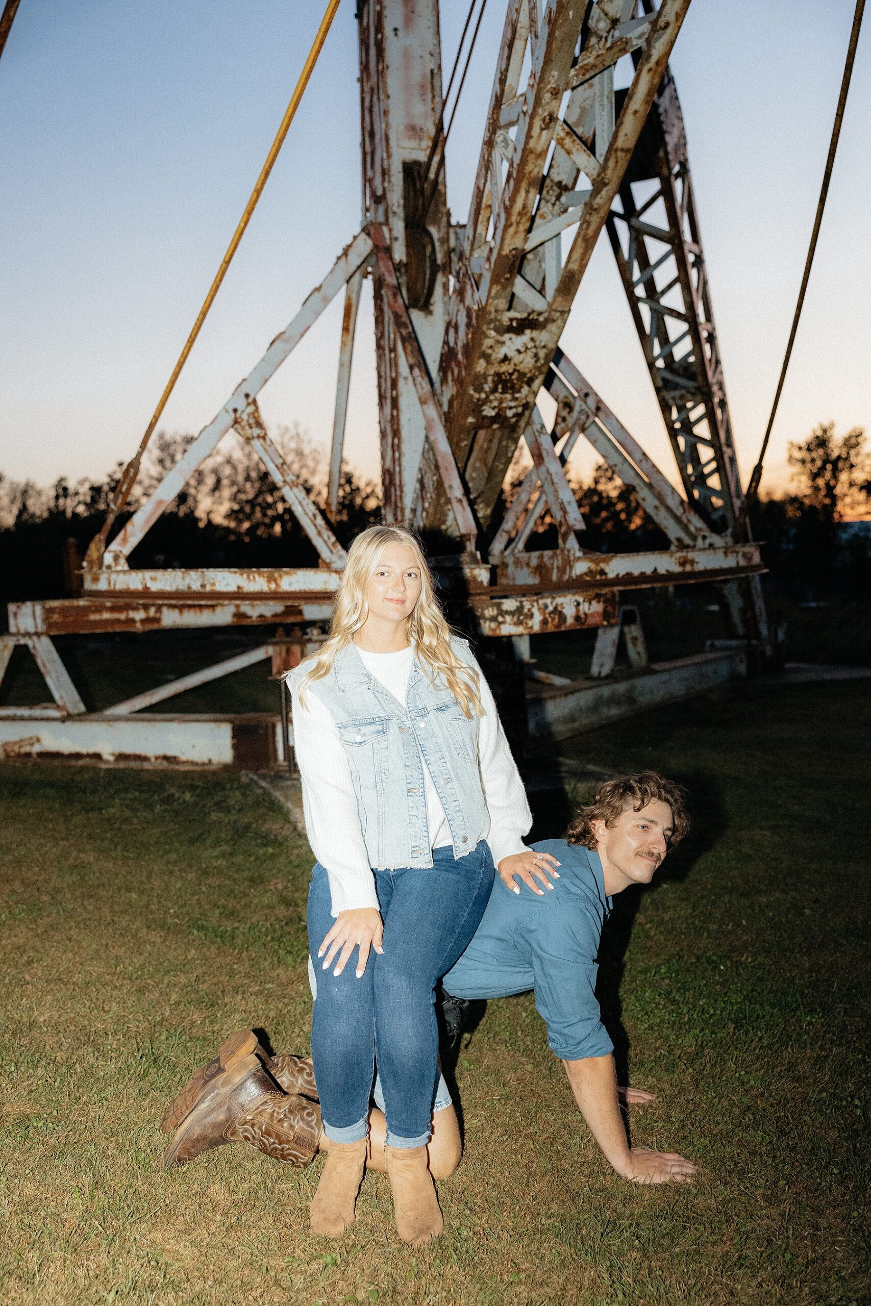 Karissa sits on Michael's back during their creative engagement photos.