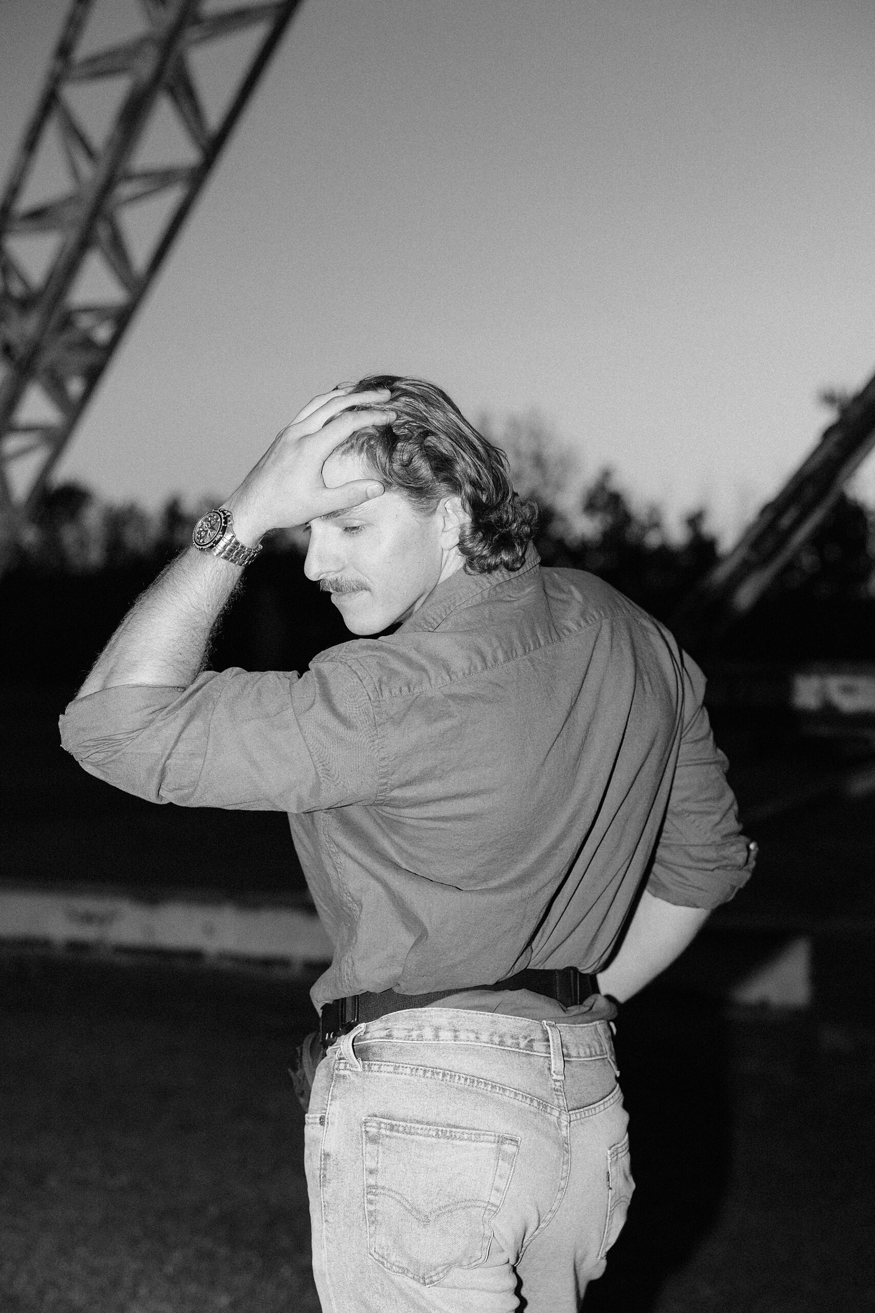 Michael posing in his jorts and fanny pack with his curly hair.