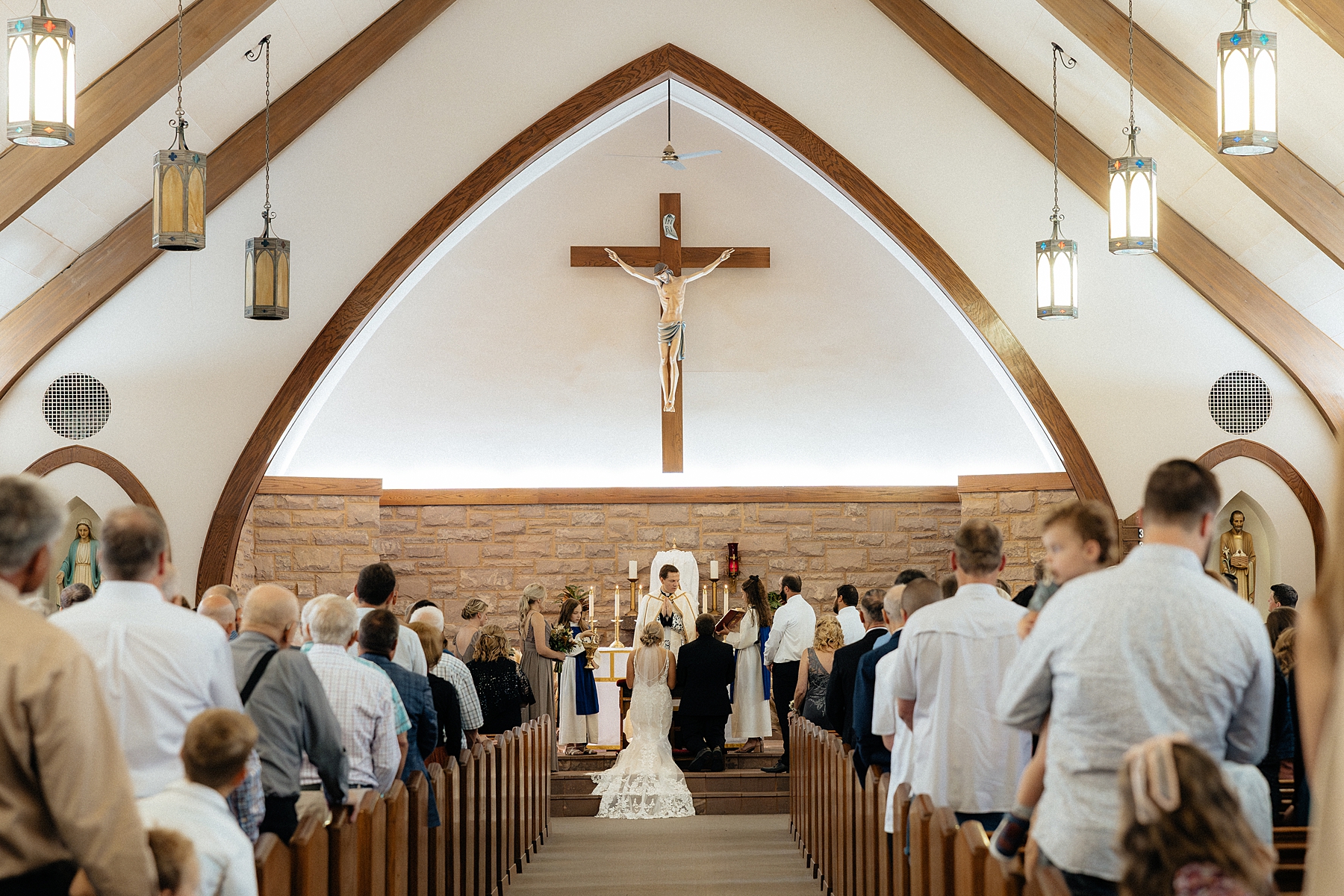 The couple kneeling at the alter.