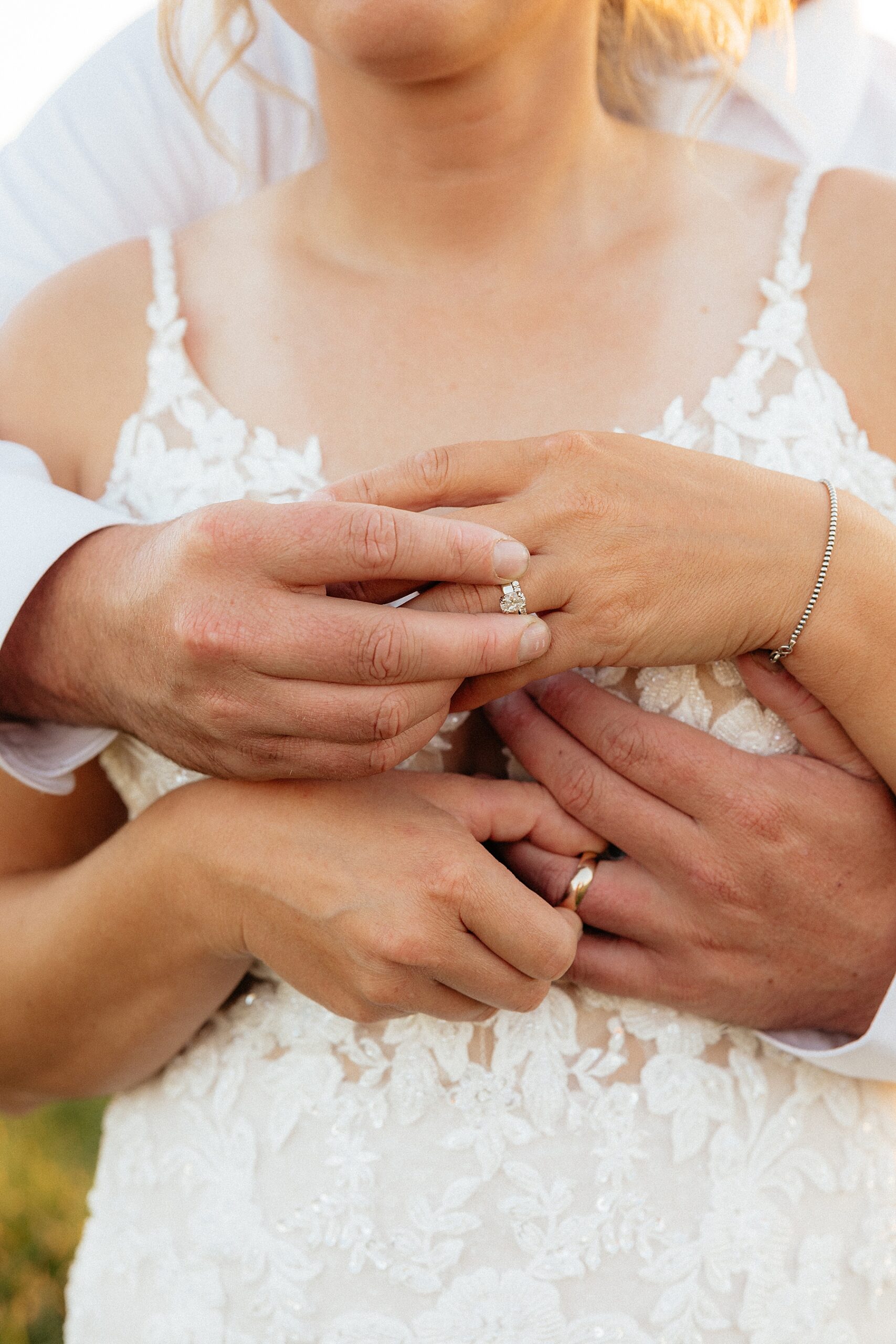 The bride and groom putting on each other's rings during golden hour portraits.