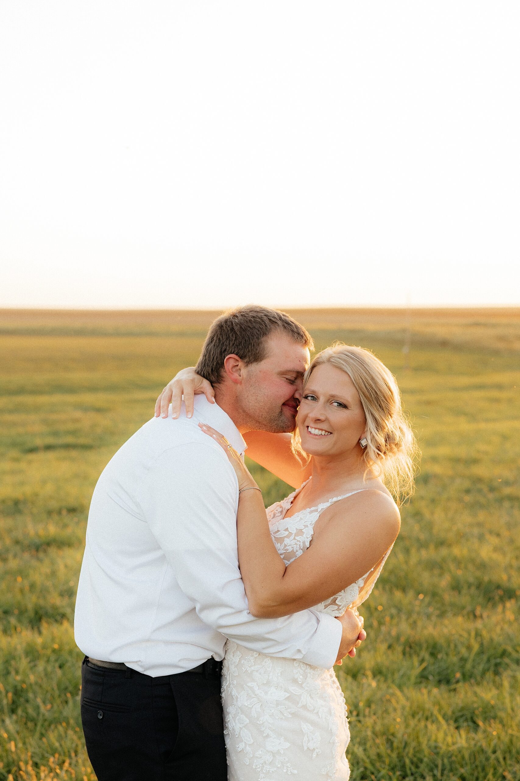 Bride and groom standing in golden hour light behind the Morton Center