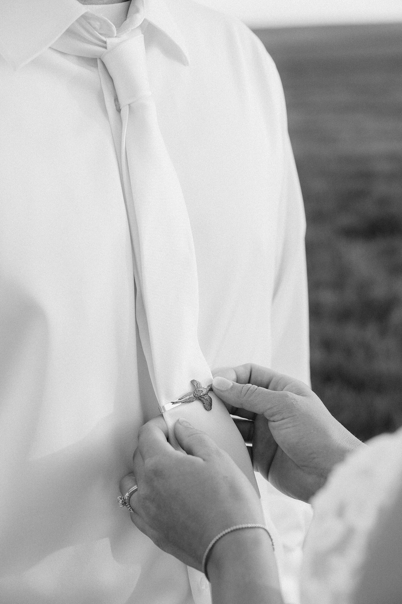 The bride adjusting the groom's tie.