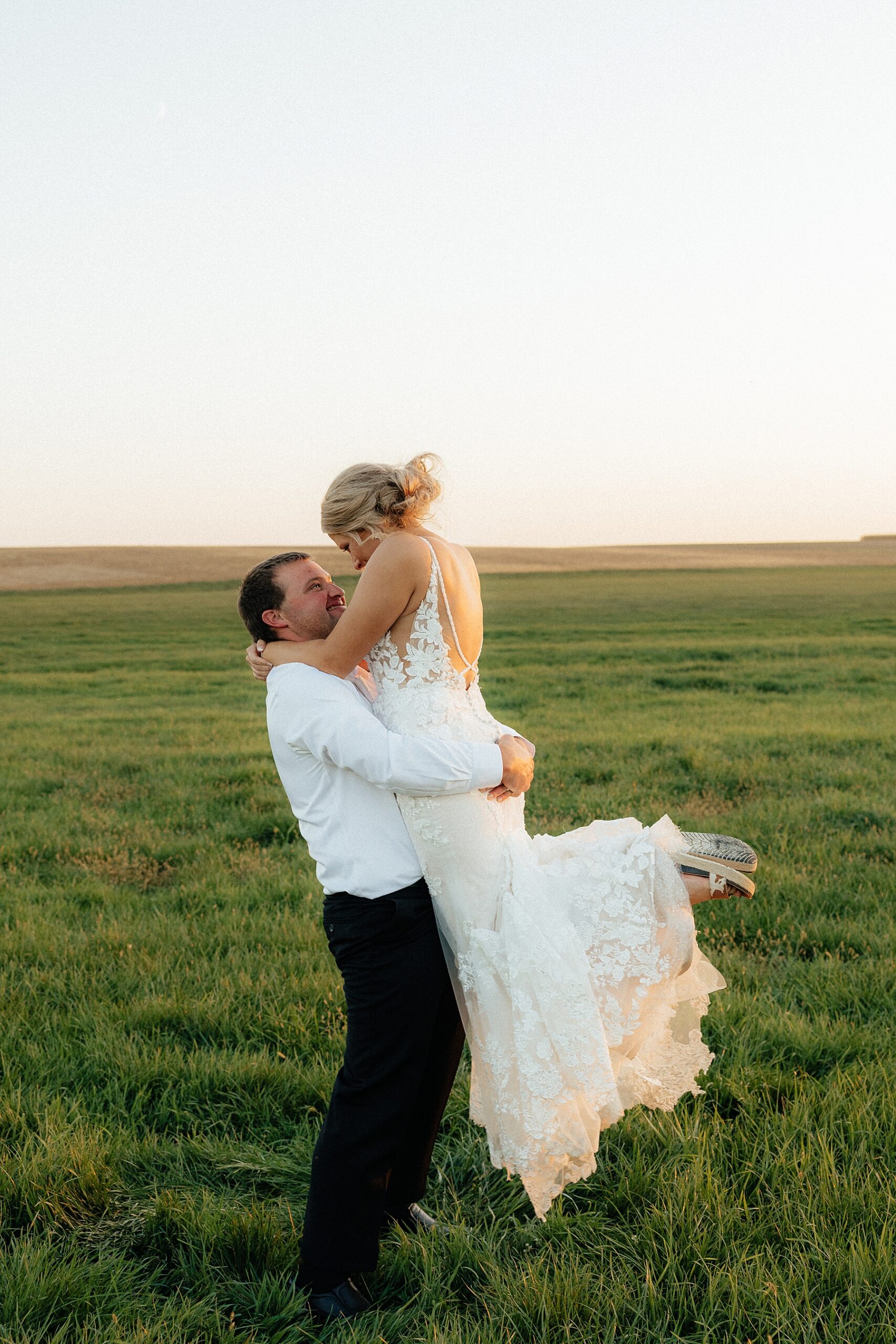 Groom lifting the bride during sunset portraits