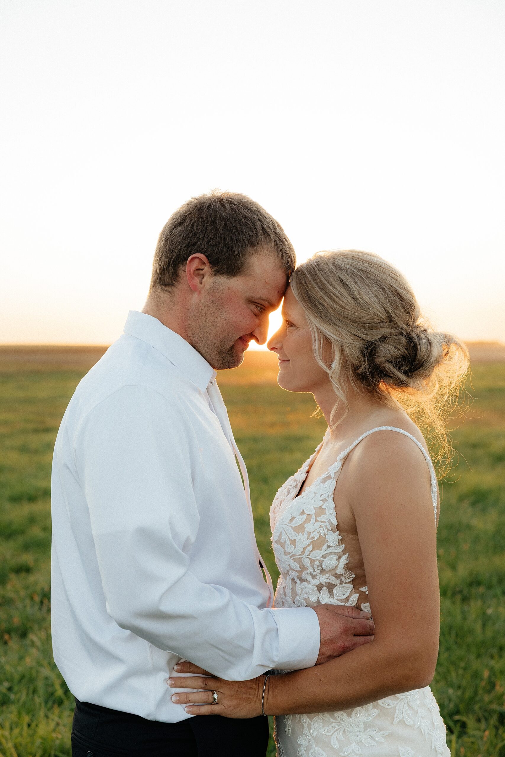 Bride and groom silhouetted at sunset