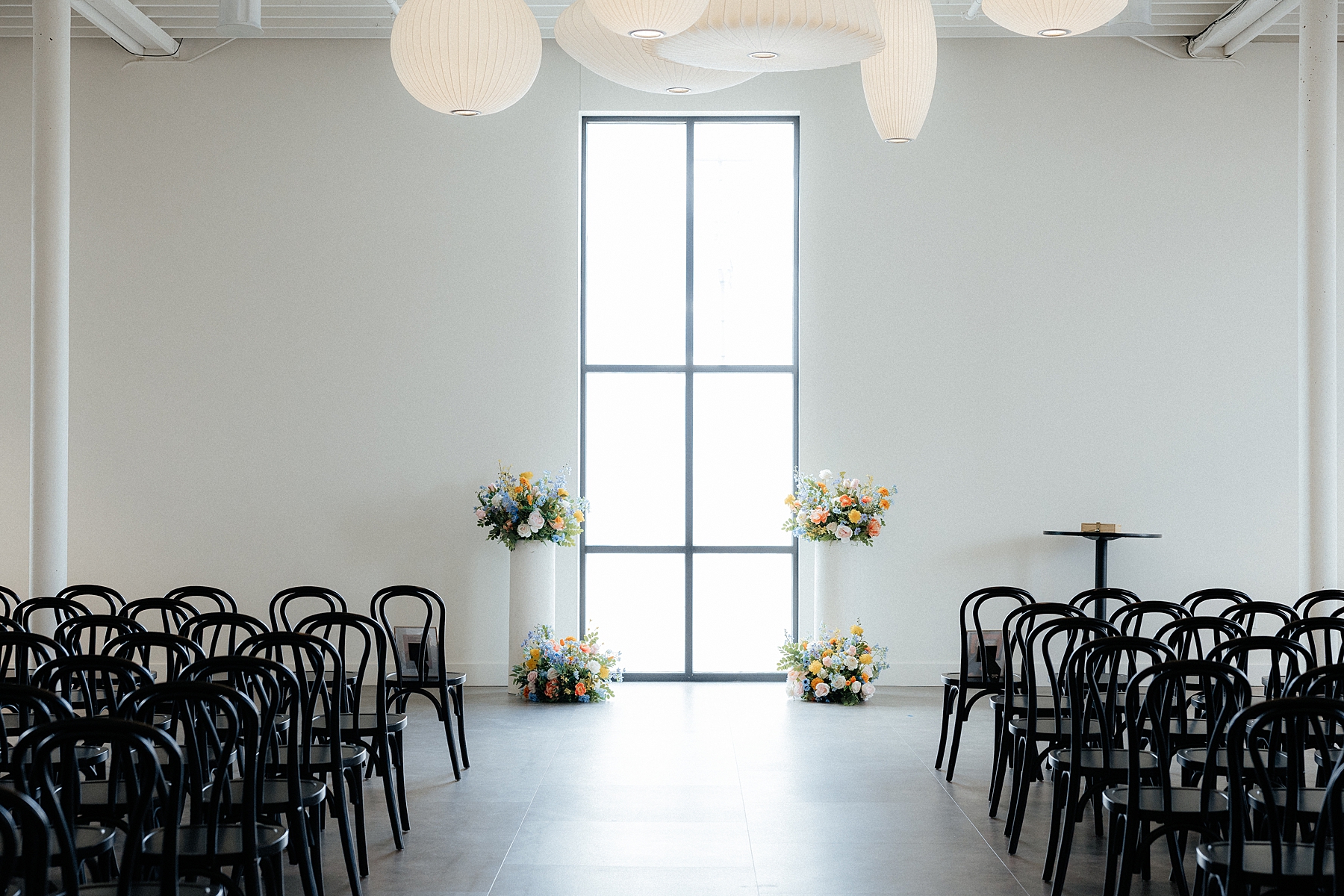 The ceremony space at Monick Yards decorated with a variety of florals.