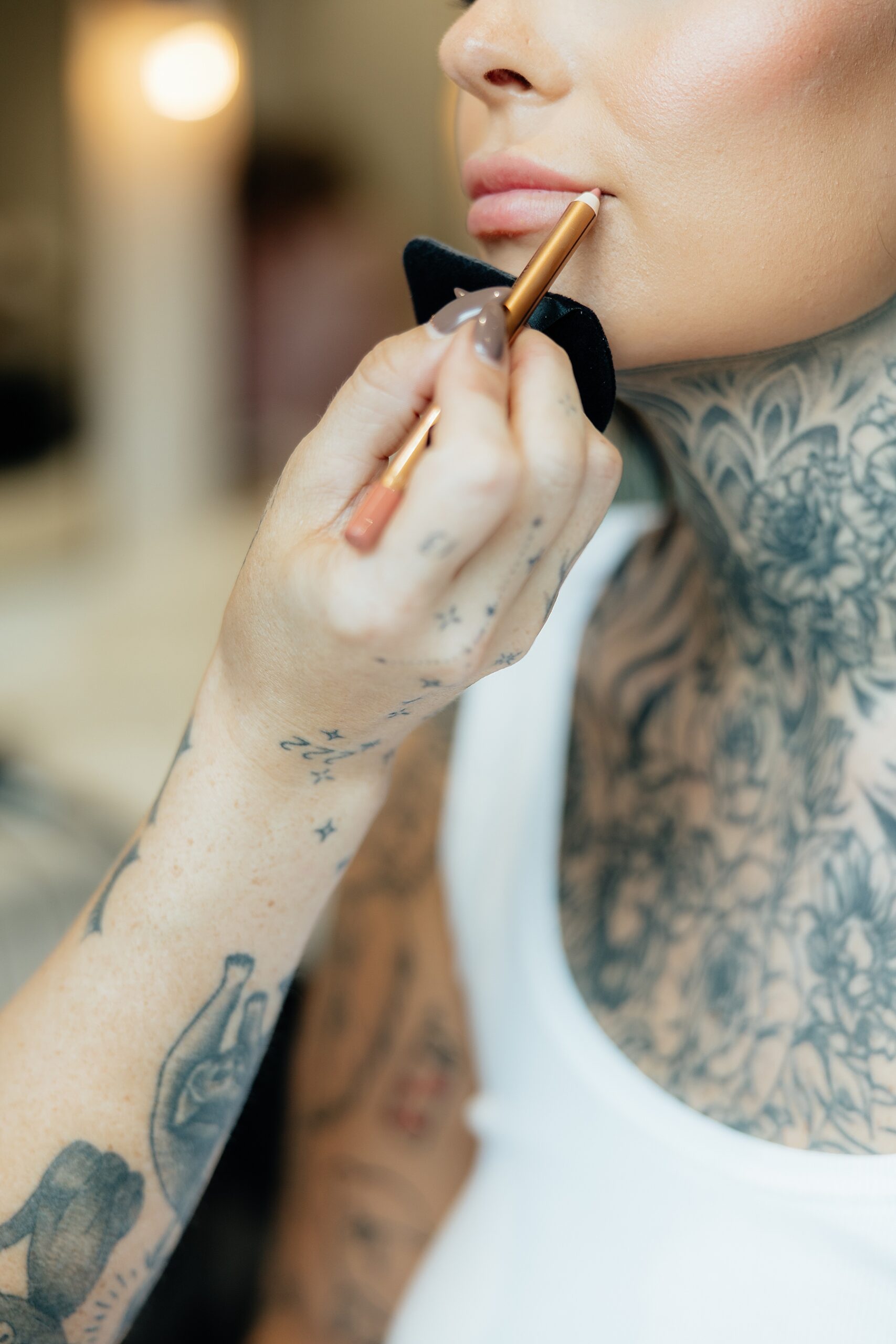 The bride getting pillow talk lip liner put on her lips.