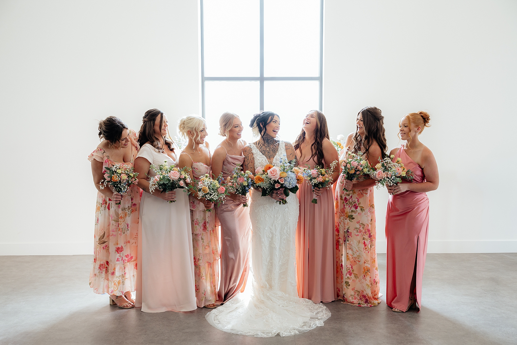 Bridesmaids laughing in a white, South Dakota wedding venue.