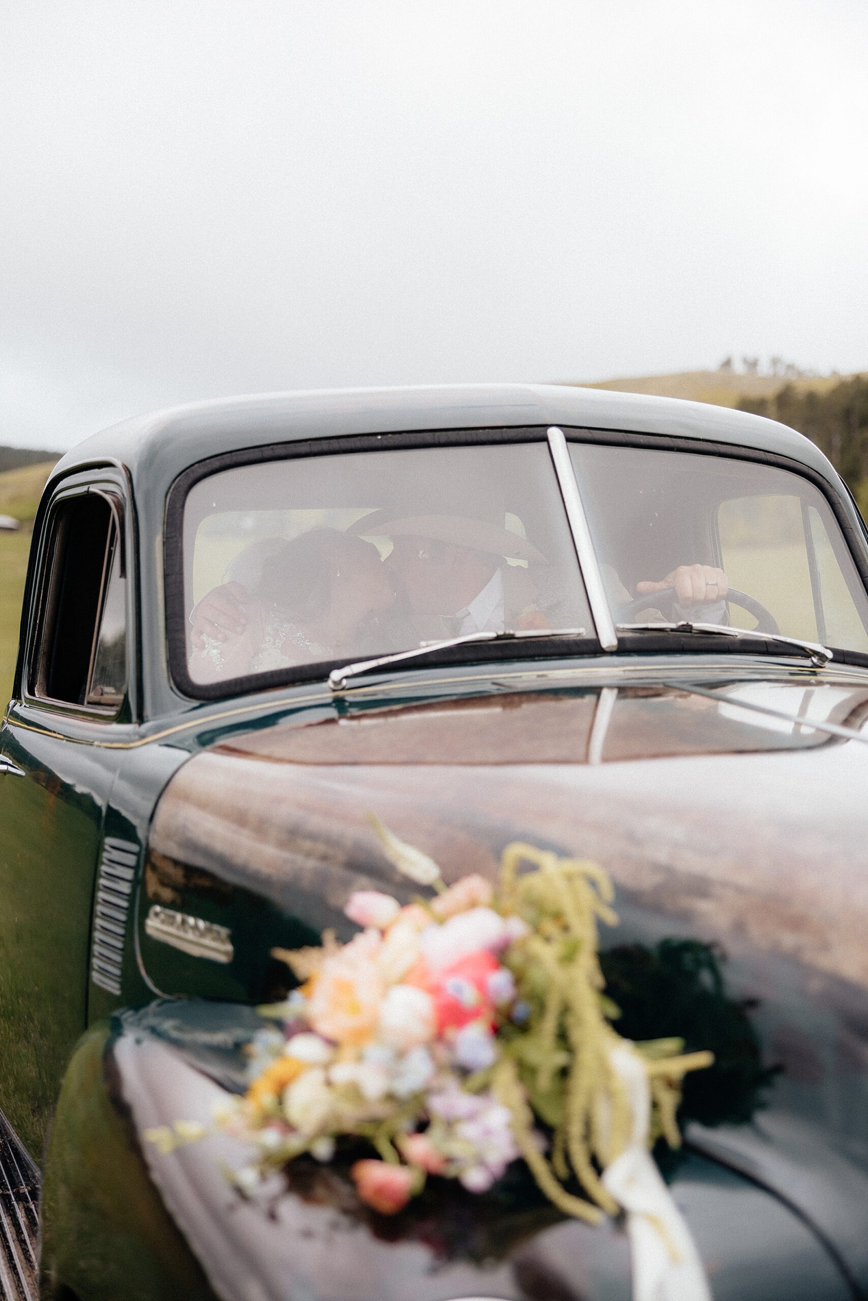 A couple kissing in a vintage Chevrolet at Muley Hill Lodge in Deadwood, South Dakota.