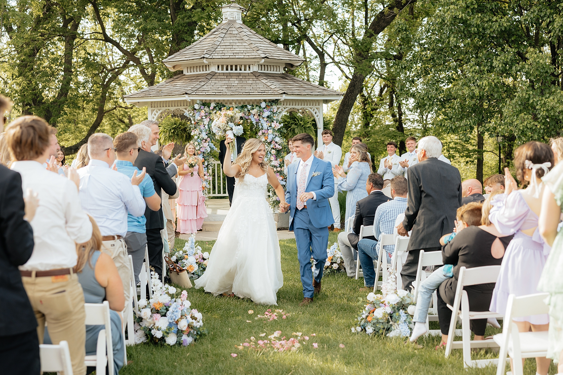 The bride and groom walking back down the aisle. The bride carrying a pastel bouquet