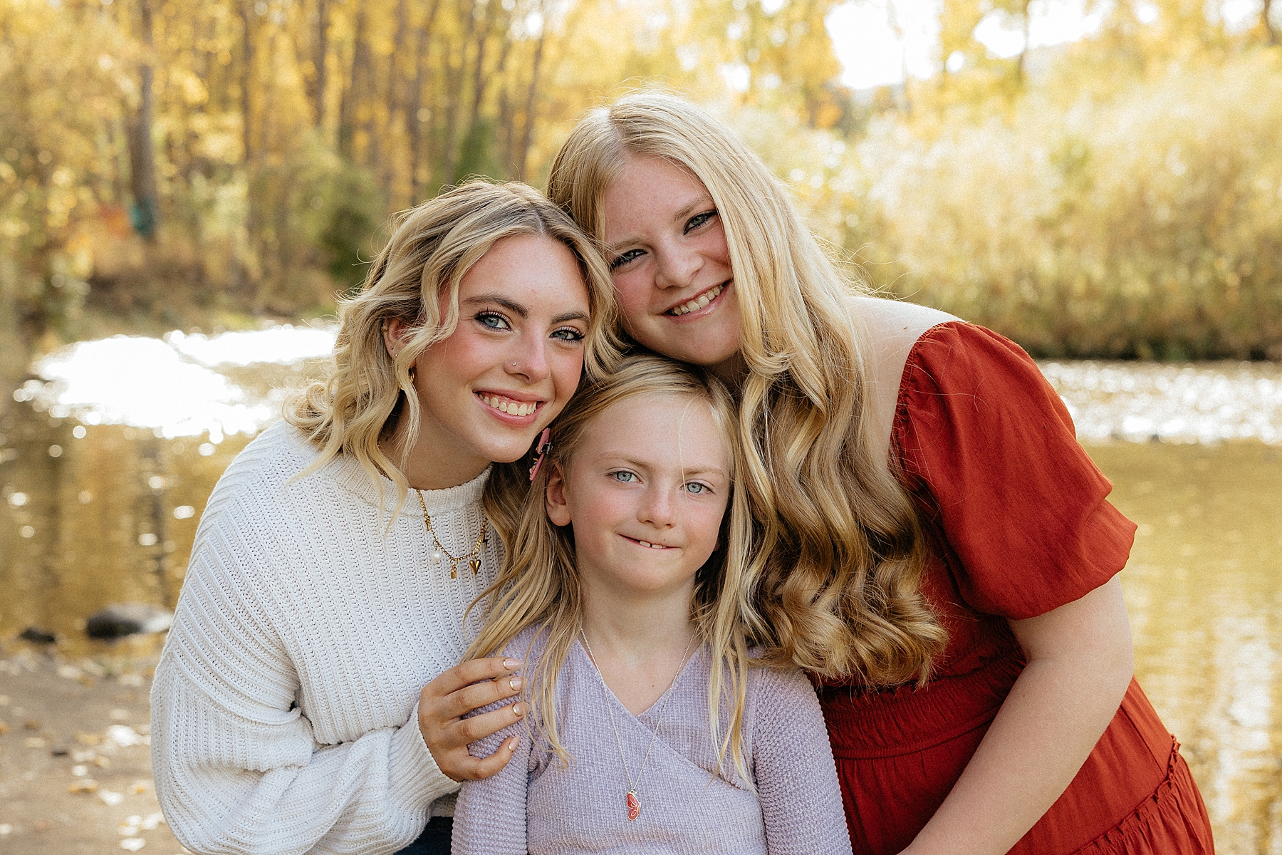 Three sisters smiling at the camera. Image taken by a Rapid City Family Photographer.