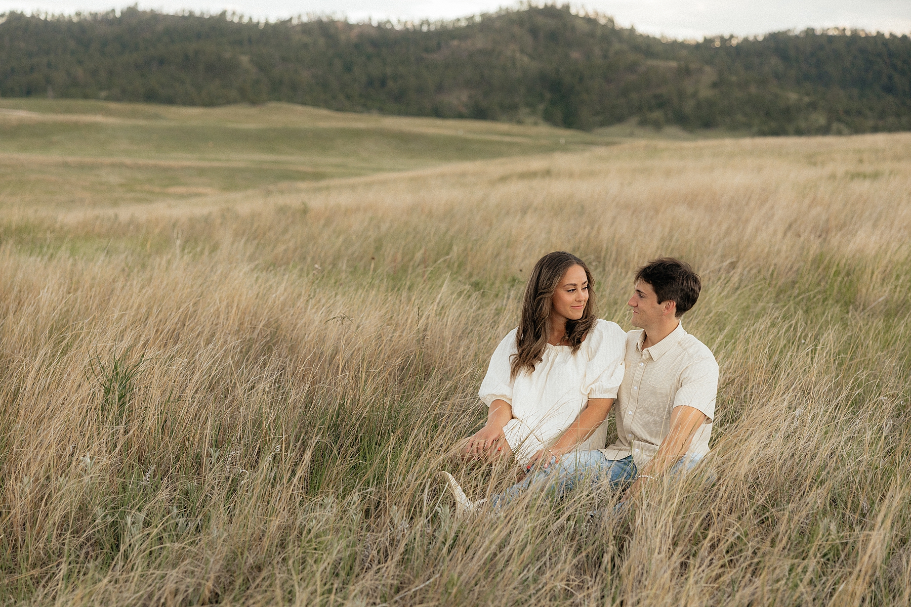 Christian and Olivia sitting in a field at Wind Cave National Park.