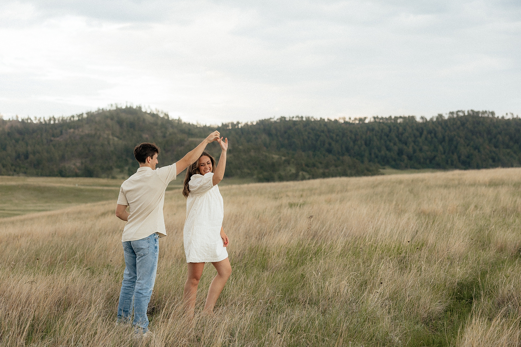 Christian spinning Olivia in a field while she laughs.