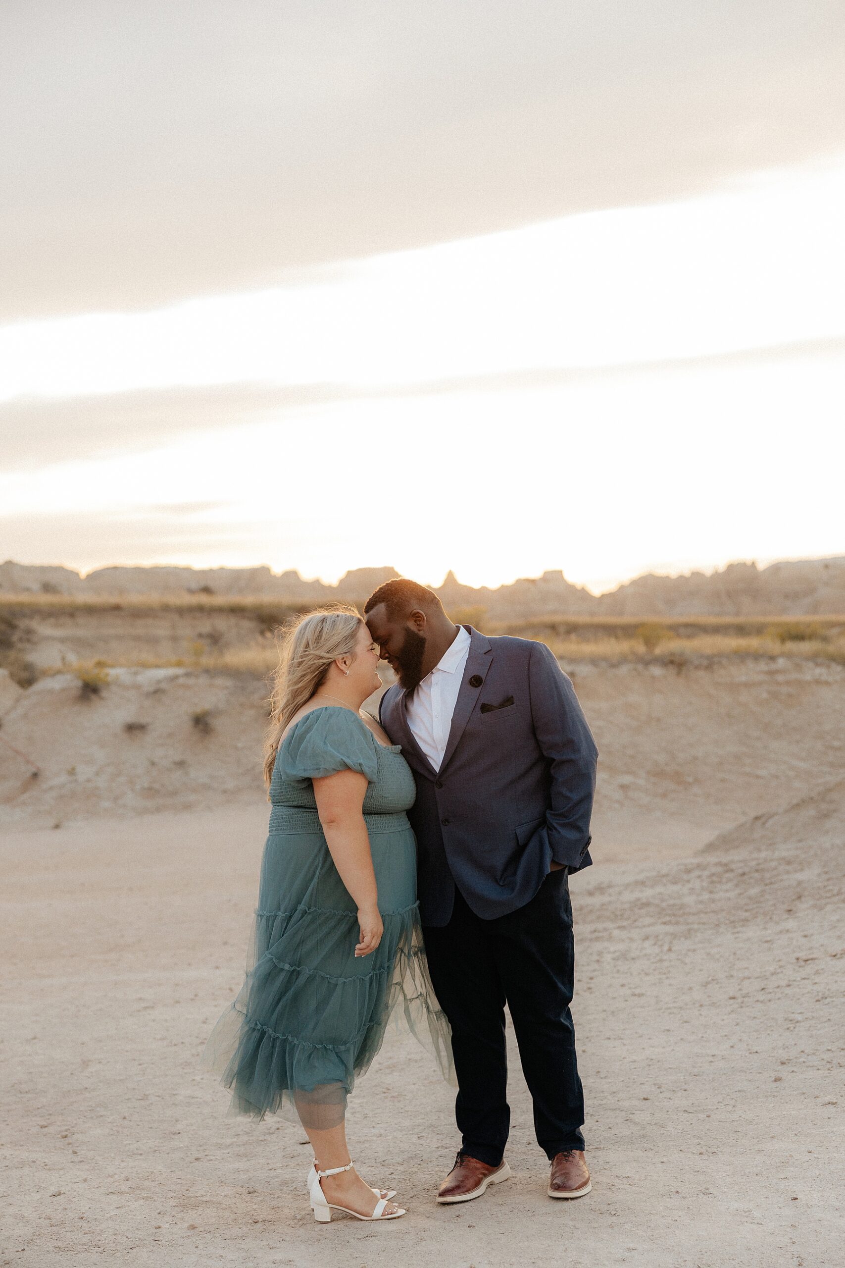 A couple standing forehead to forehead at their engagement session.