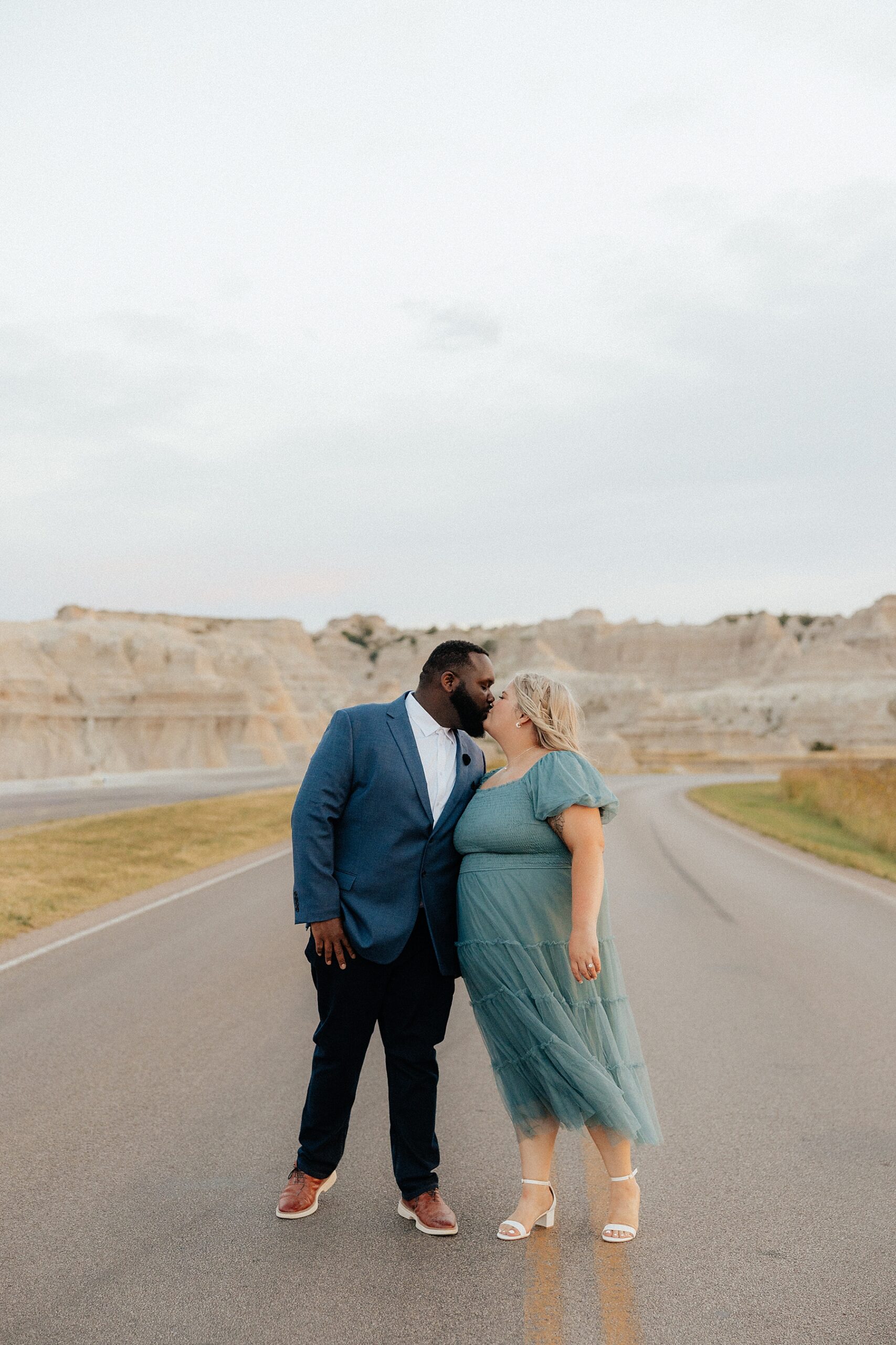 A couple kissing on the road in Badlands National Park.