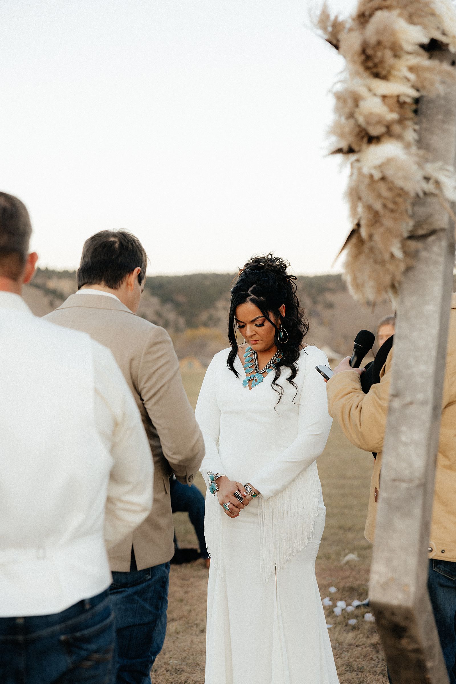 The bride bowing her head for prayer at the ceremony.