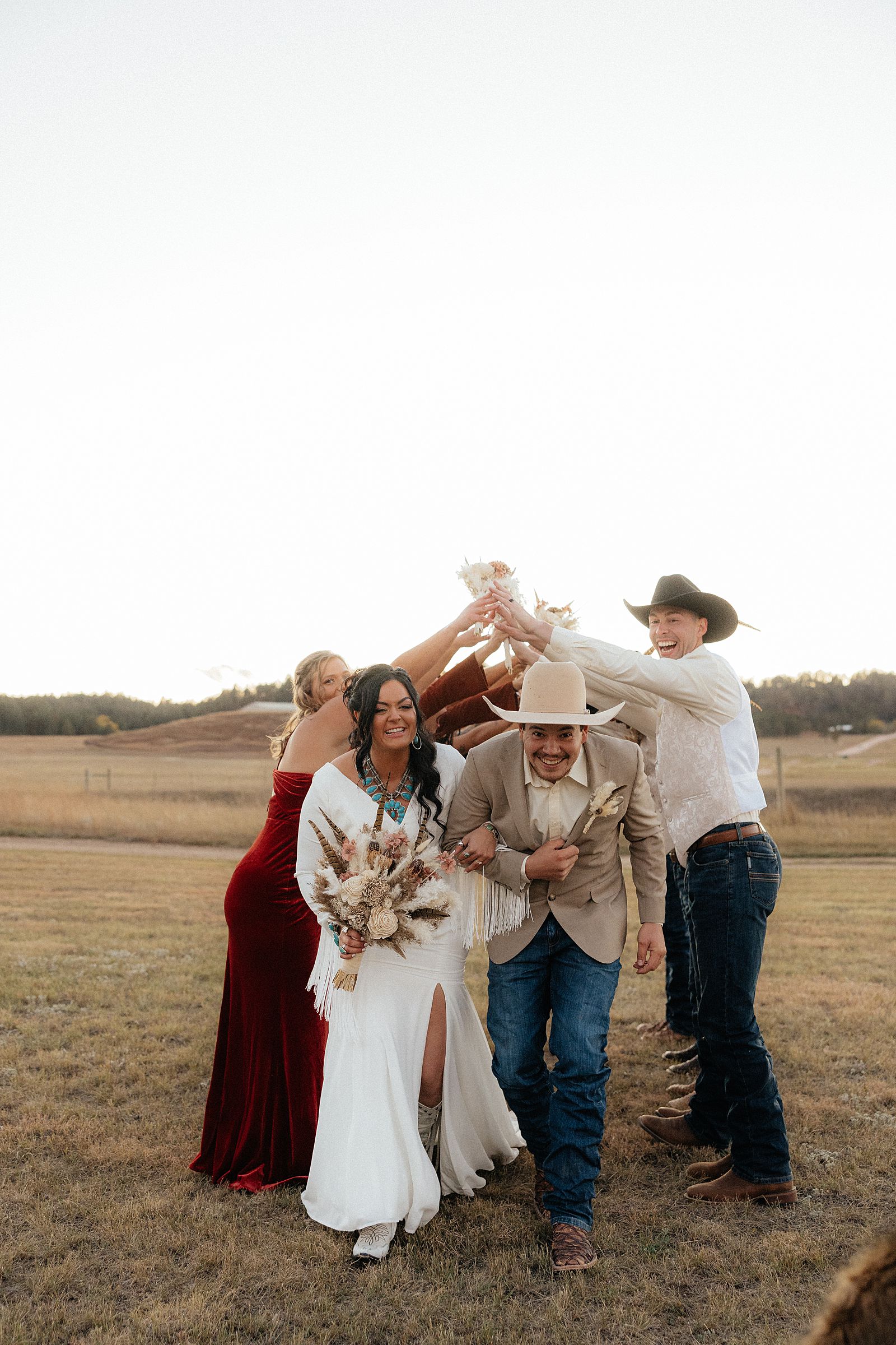 The bride and groom running through a wedding party tunnel.