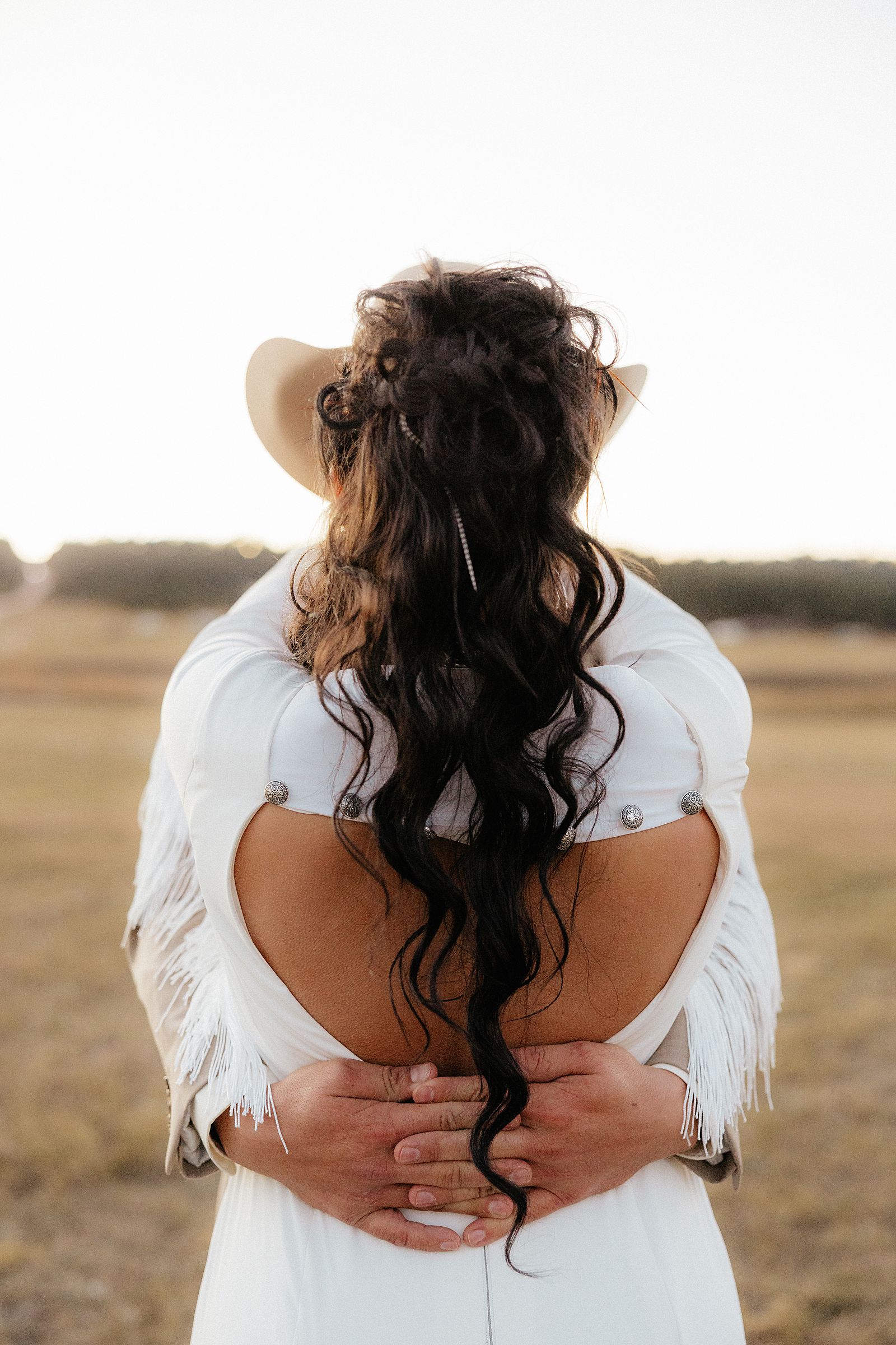 The groom wraps his arms around his bride.
